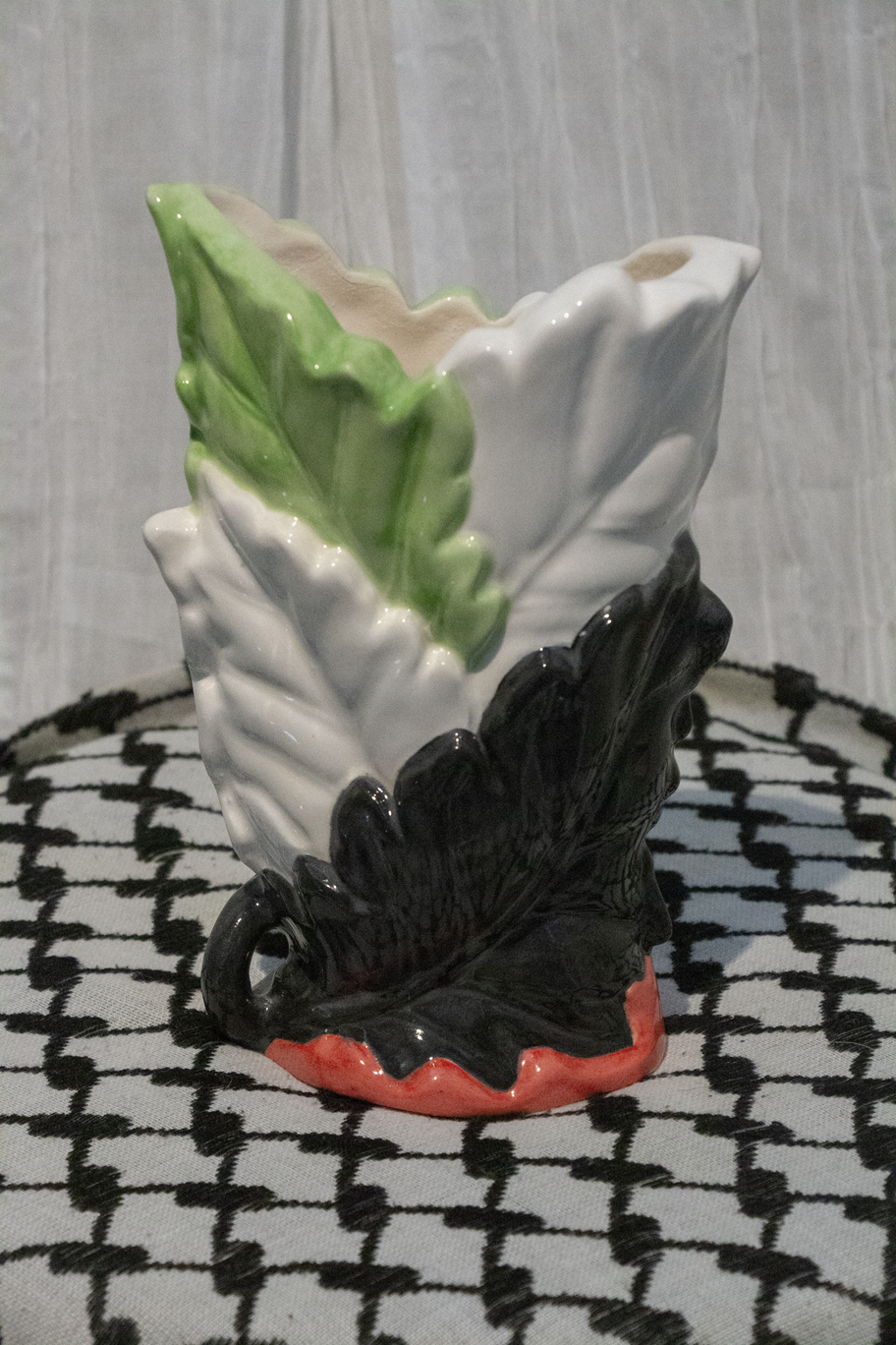 "Vase 9", a small ceramic vase of leaves painted in green, black, and red to represent the Palestinian flag