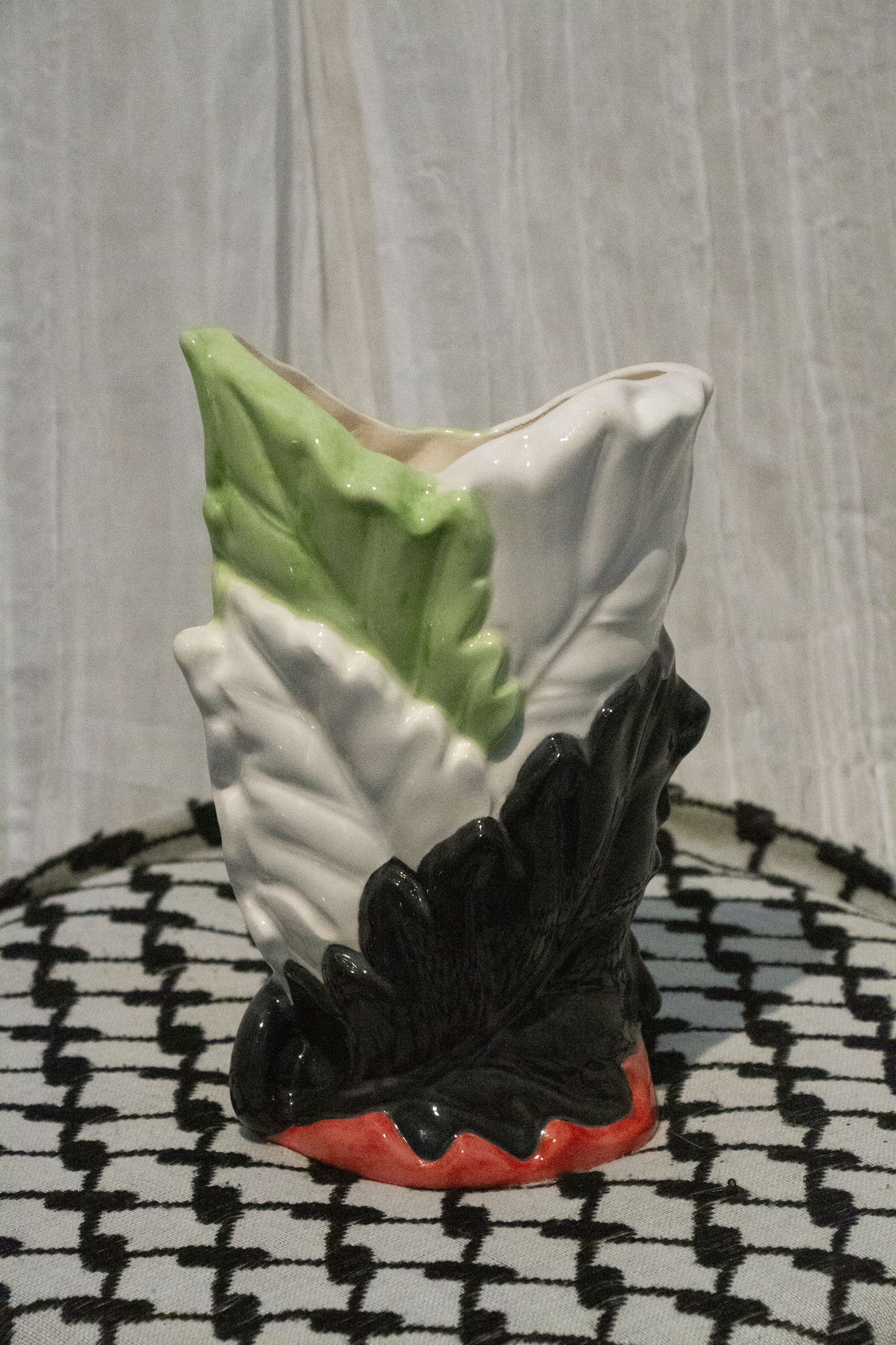 "Vase 3", a small ceramic vase of leaves painted in green, black, and red to represent the Palestinian flag