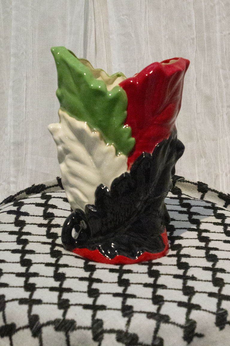 "Vase 1", a small ceramic vase of leaves painted in green, black, and red to represent the Palestinian flag