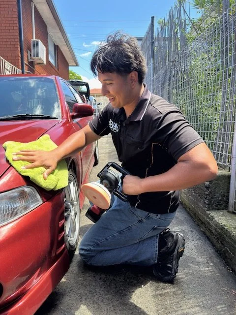 Detailer wiping polishing residue from car paint after paint correction in Wollongong.