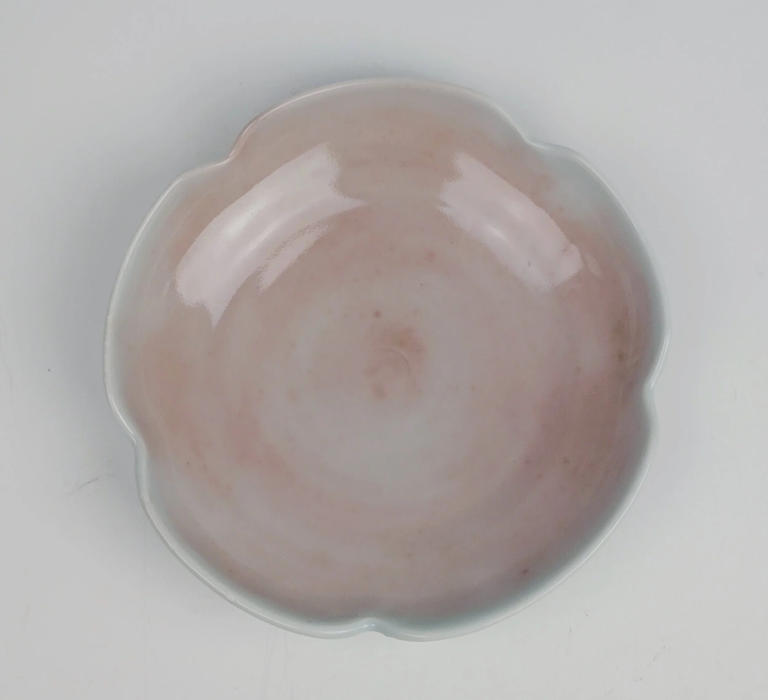 Empty flower-shaped dish on a white surface.