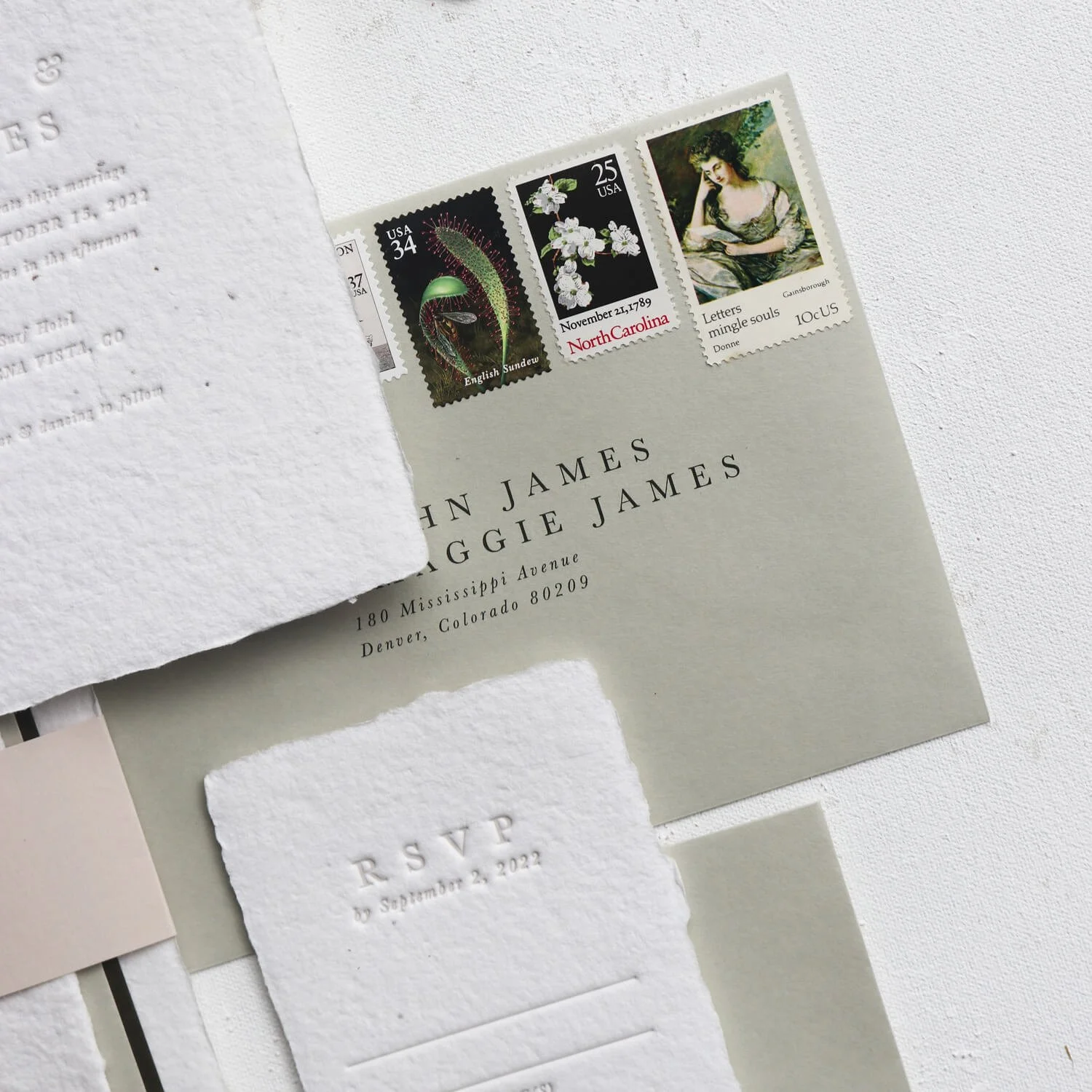 flatlay of wedding invitations with vintage stamps on the envelopes