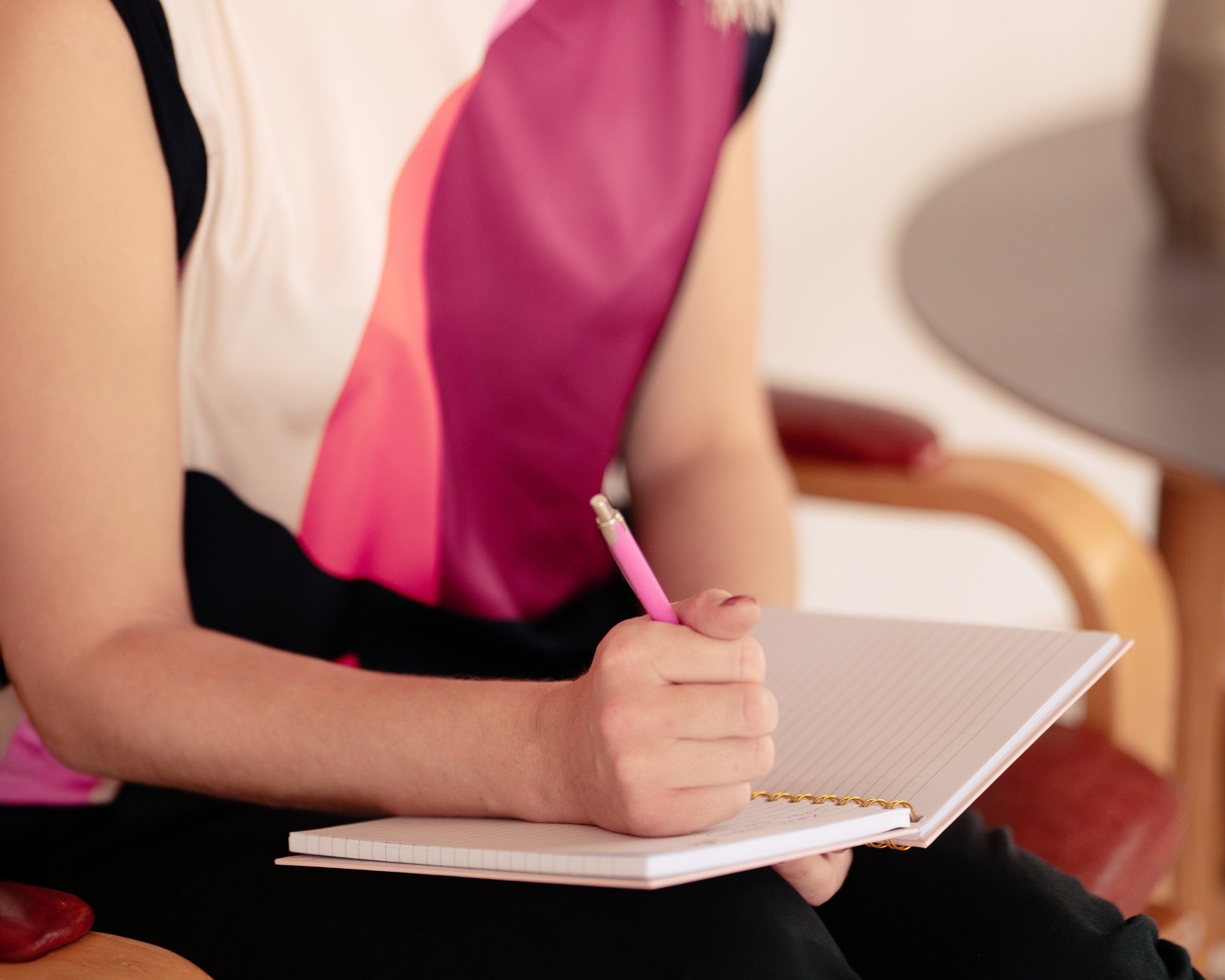 Rikke Lundsfryd, business wingwoman, skriver i en notesbog med lyserødt pen.