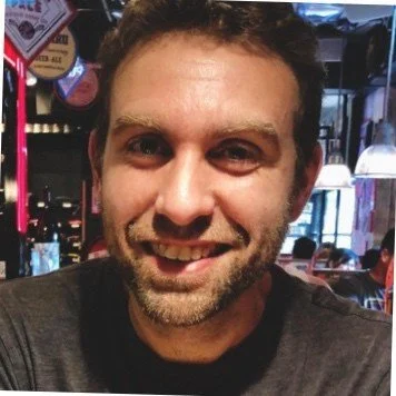Man smiling in a restaurant with dim lighting
