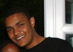 A person smiling near a window.