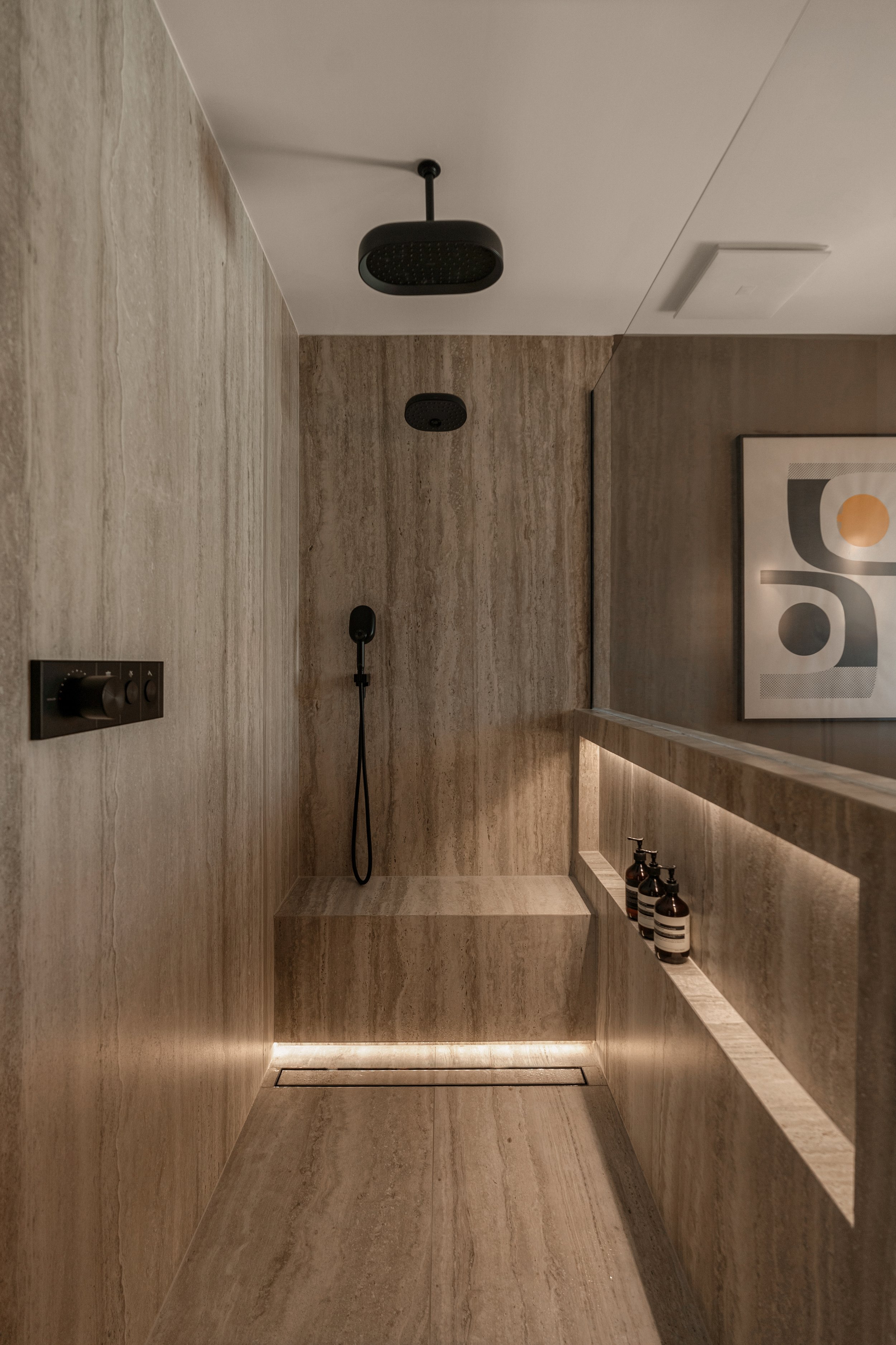 A close-up of the shower bench featuring integrated LED lighting and modern stonework.
