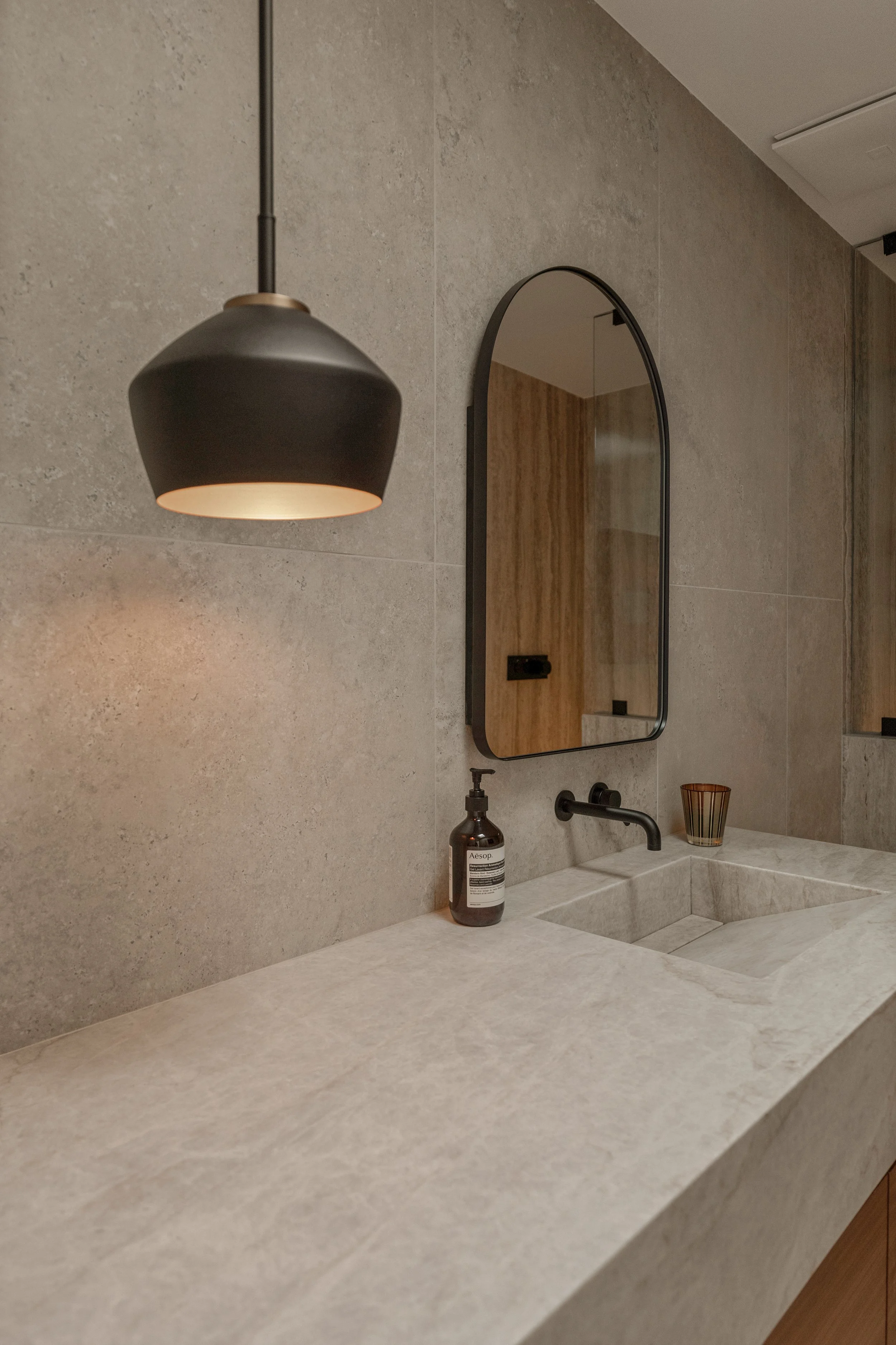 A detail shot highlighting the beautiful stone craftsmanship, warm lighting, and refined finishes of the remodel.