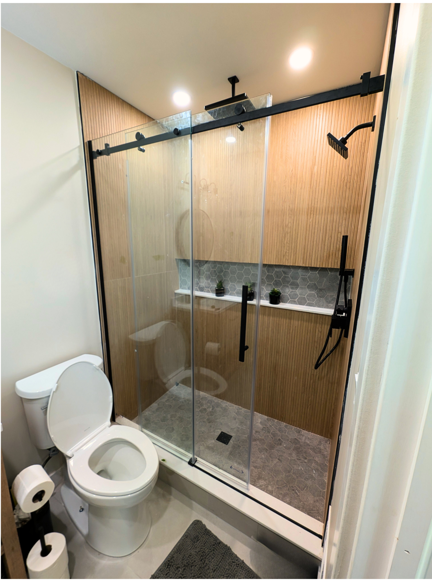 Modern kitchen with white cabinets, blue subway tile backsplash, stainless steel sink, wooden countertops, and a refrigerator. The kitchen has a hardwood floor and a window providing natural light.