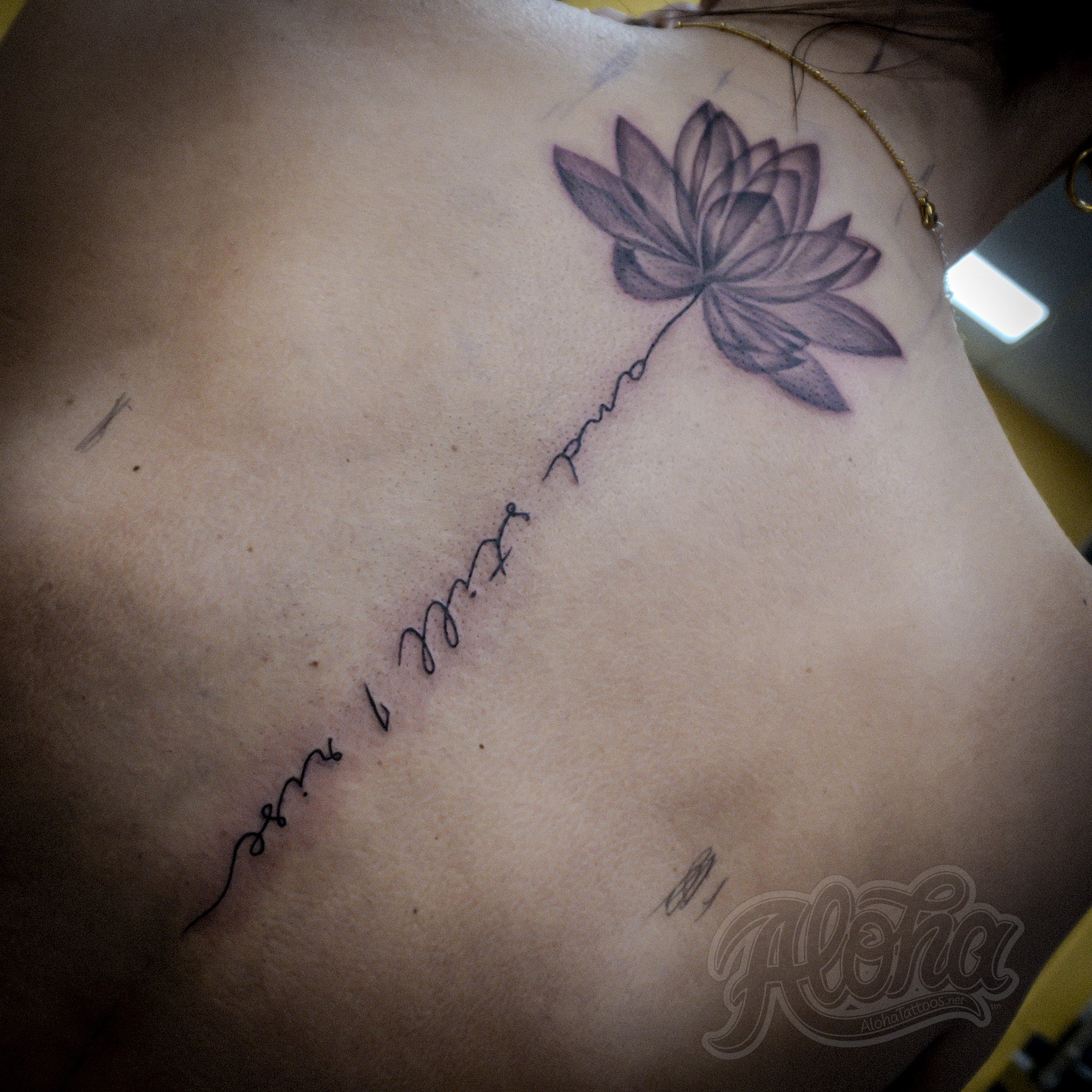 Black and grey illustrative tattoo with lettering