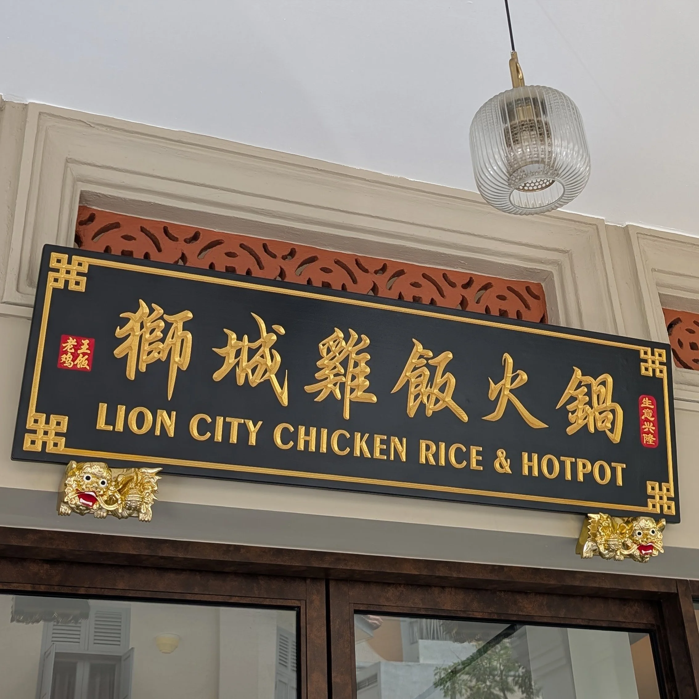 Custom handcrafted Hei Jin wooden signboard featuring gold Chinese characters, English restaurant name, and carved guardian lions for a traditional Chinese restaurant.