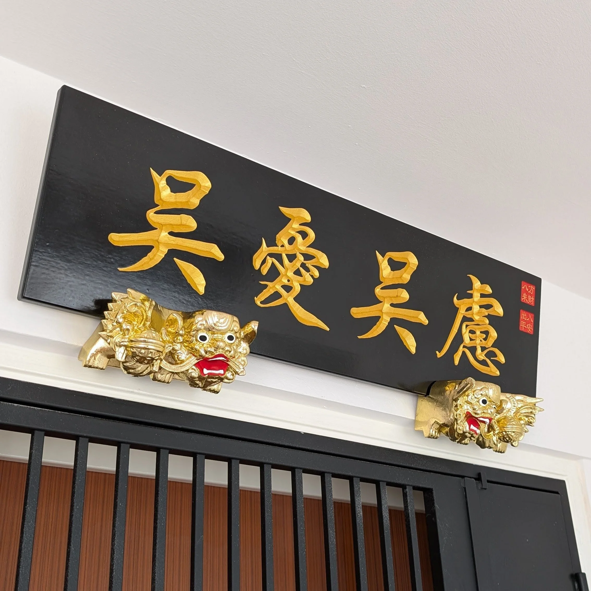 Traditional Hei Jin Chinese wooden signboard with hand-painted gold calligraphy, black lacquer finish, carved guardian lions, and maker's seal.