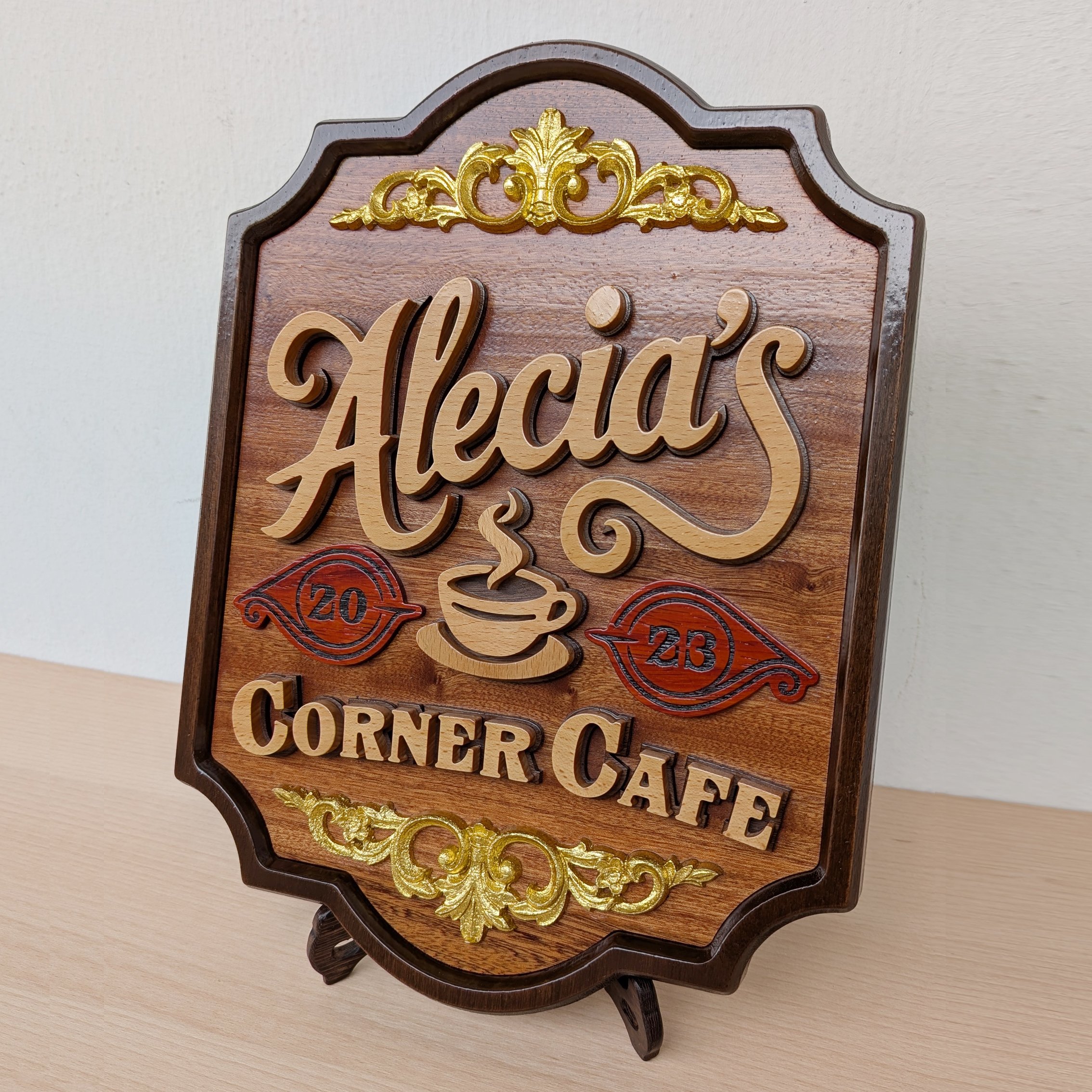 Handcrafted wooden cafe sign with raised lettering, carved coffee cup motif, decorative gold accents, and rich walnut wood finish.