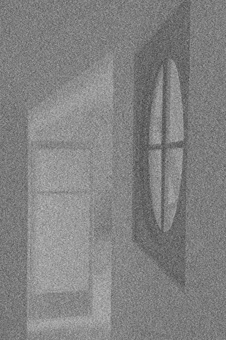 Fenêtre ovale avec 4 quadrants dans une pièce sombre, vue de l'intérieur.