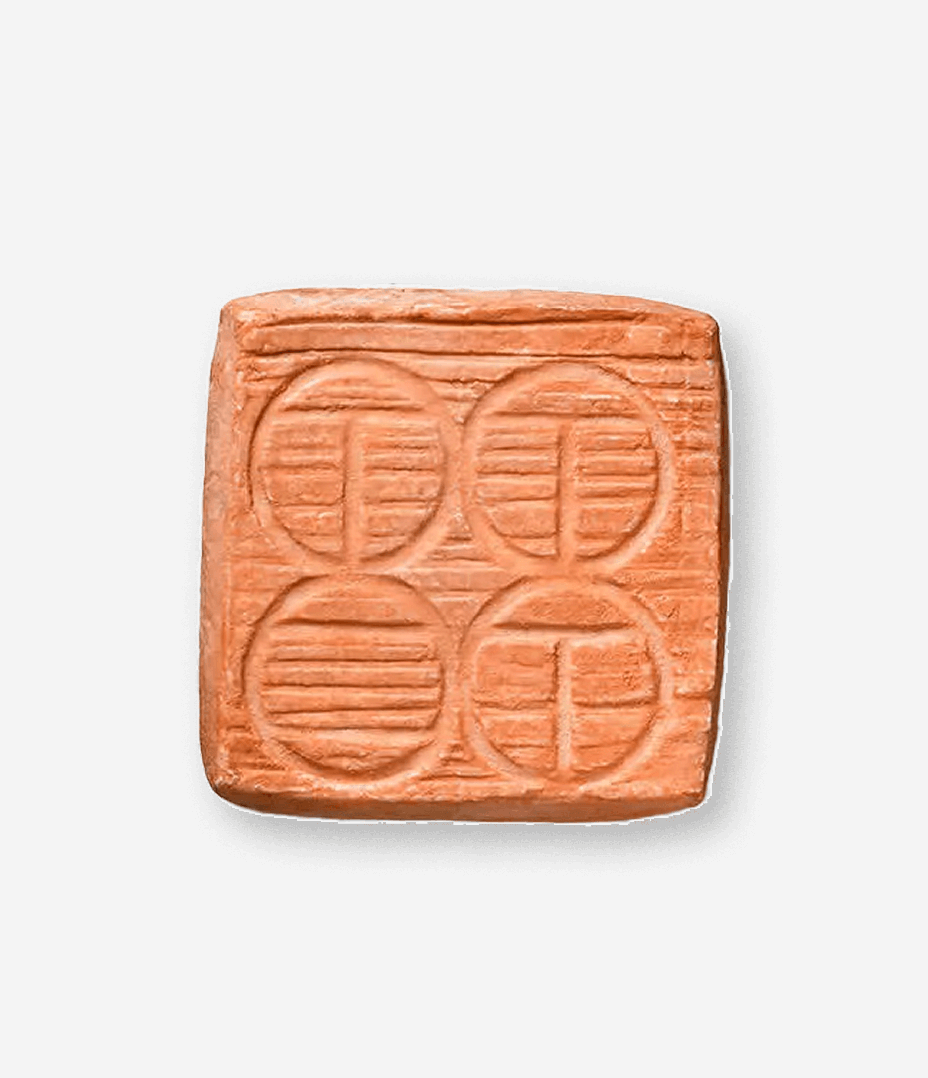 A pink pill with six circular embossed designs on its surface, arranged in two rows of three.