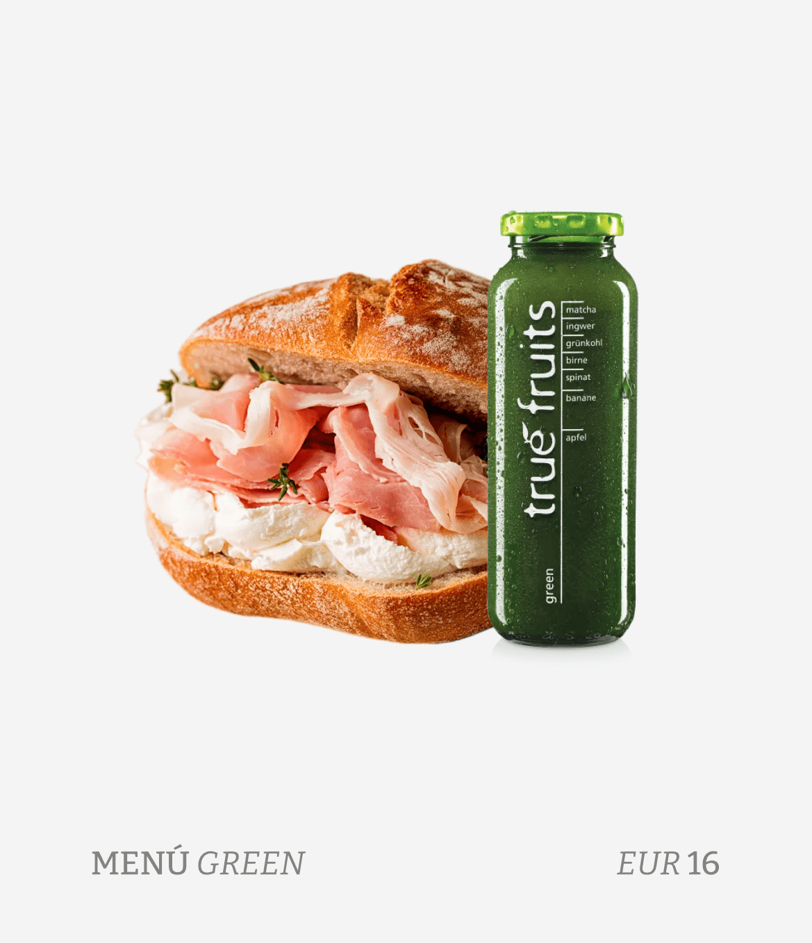 A sandwich on a baguette bread with ham and cheese, alongside a green bottled juice labeled 'true fruits' with ingredients like matcha, ginger, spinach, banana, and apple.