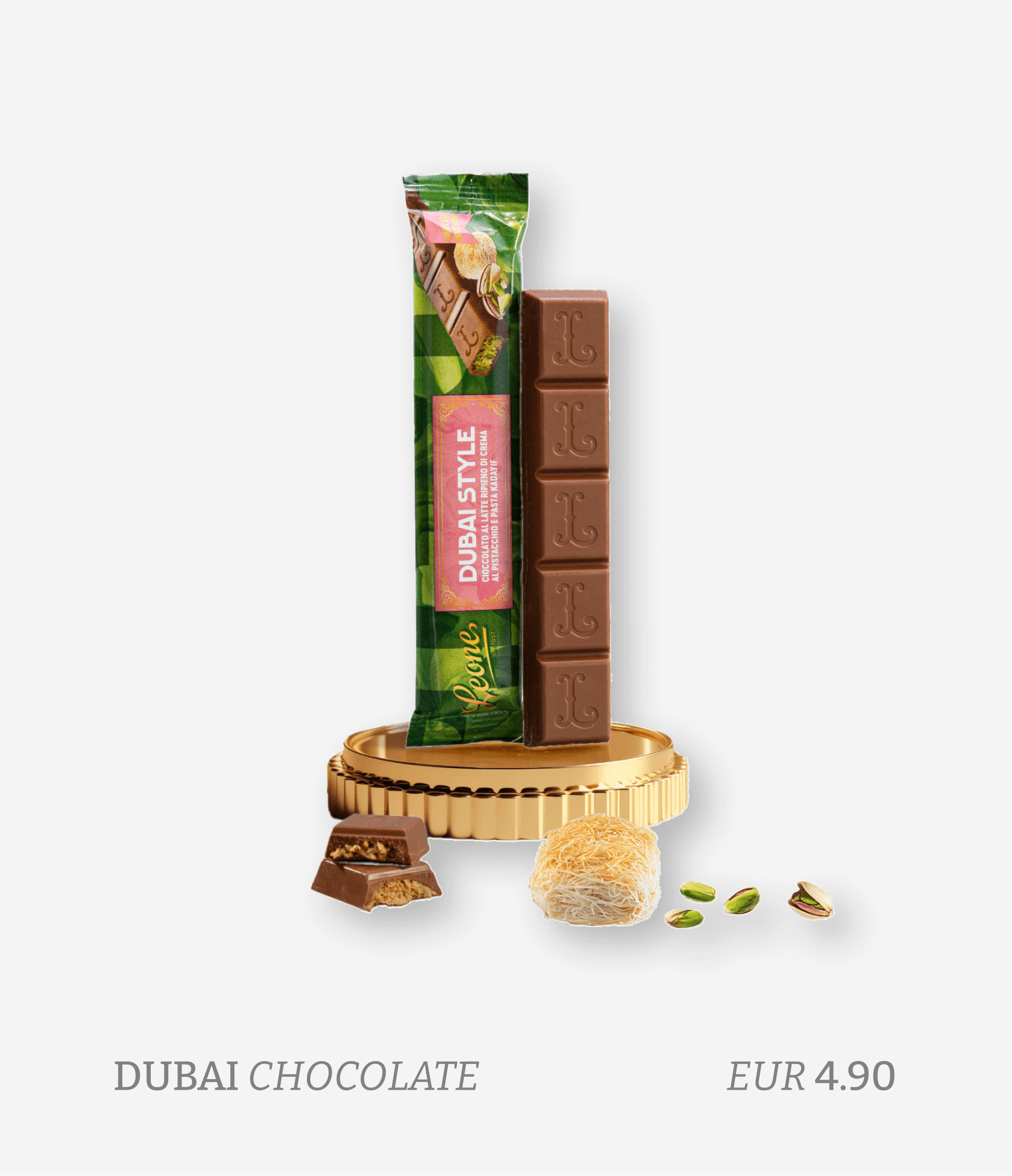 A box of Dubai Style chocolate with five pieces of chocolate stacked vertically, a gold coin, a split piece of chocolate, a piece of Middle Eastern sweet, pistachios, and a price of EUR 4.90 displayed at the bottom.