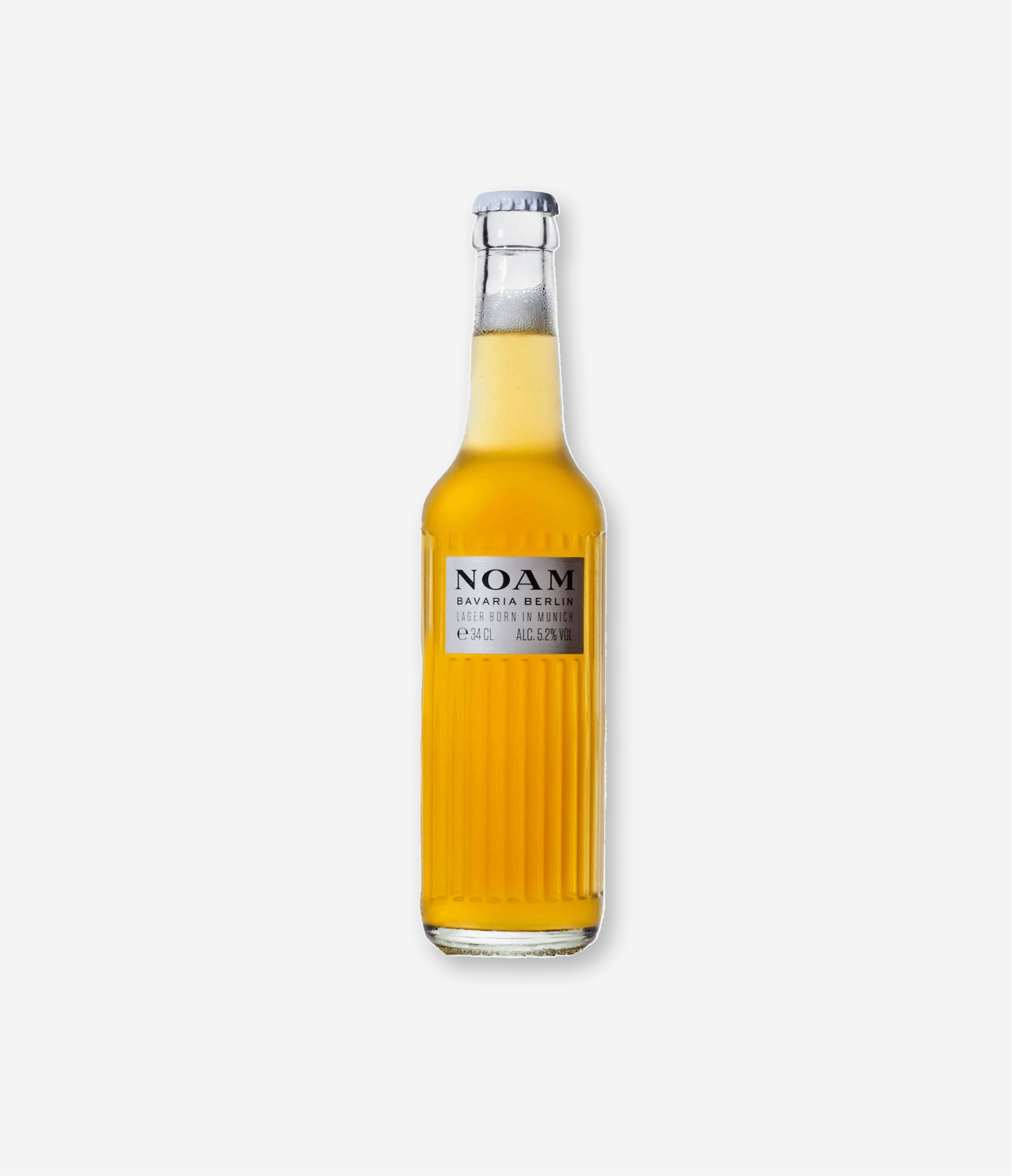 A clear glass bottle of beer with a silver cap, labeled 'NOAM Bavaria Berlin Lager, born in Munich, 34cl, 5.2% alcohol, with a yellow liquid inside.