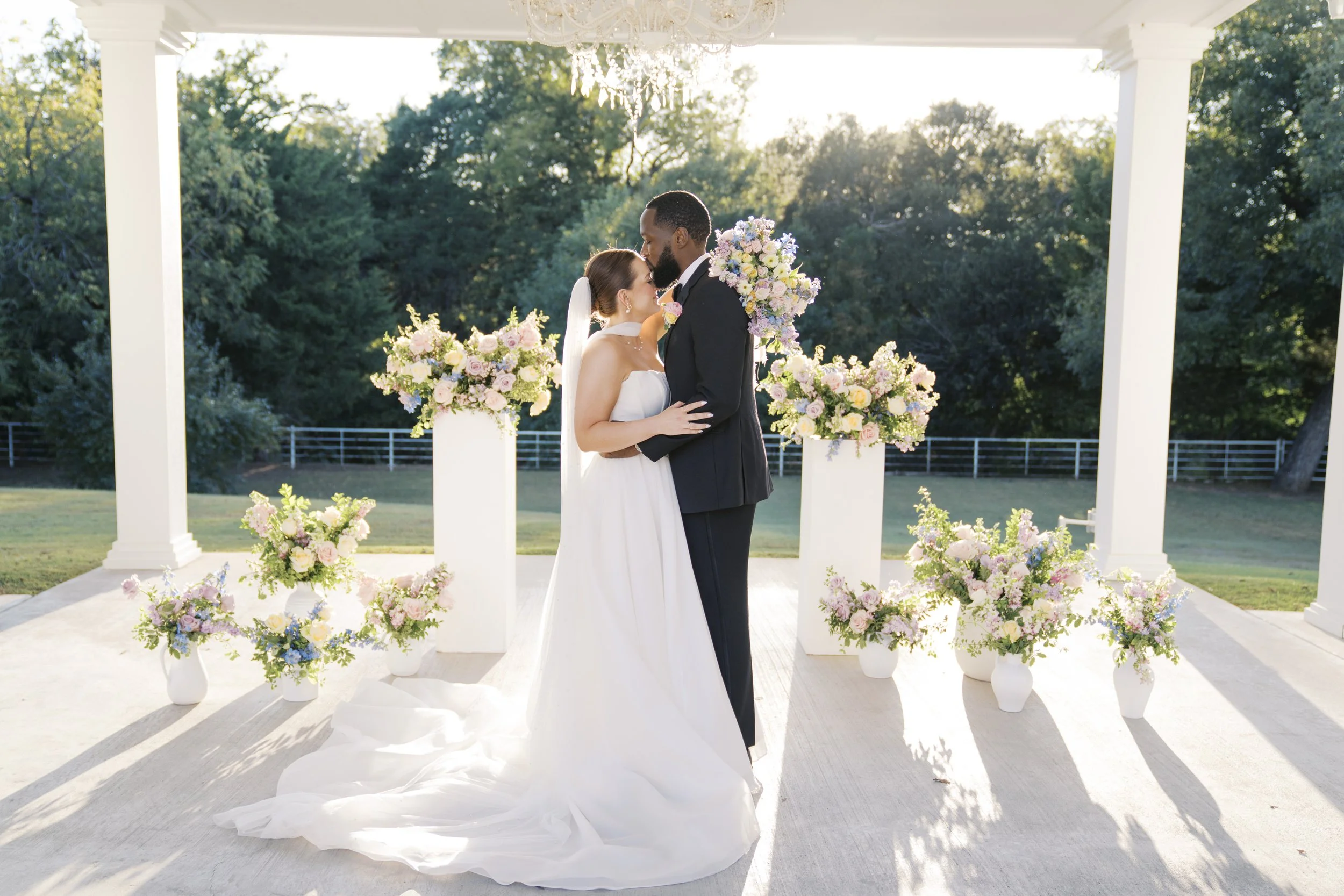 couple posing at their ceremony with bright colorful wedding florals at elevated wedding in Dallas, Texas.