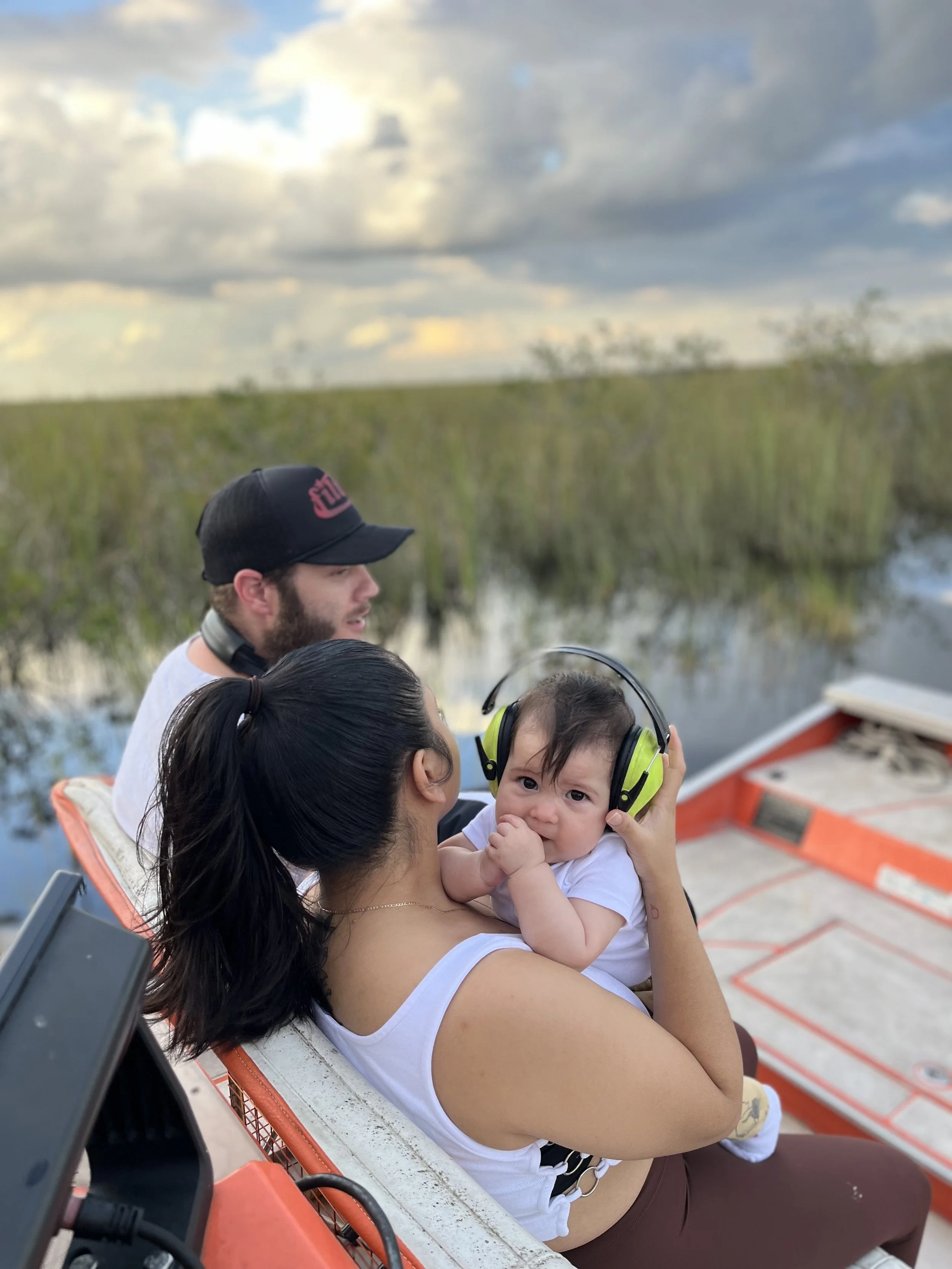 Family with a baby aboard a boat in the Everglades marsh