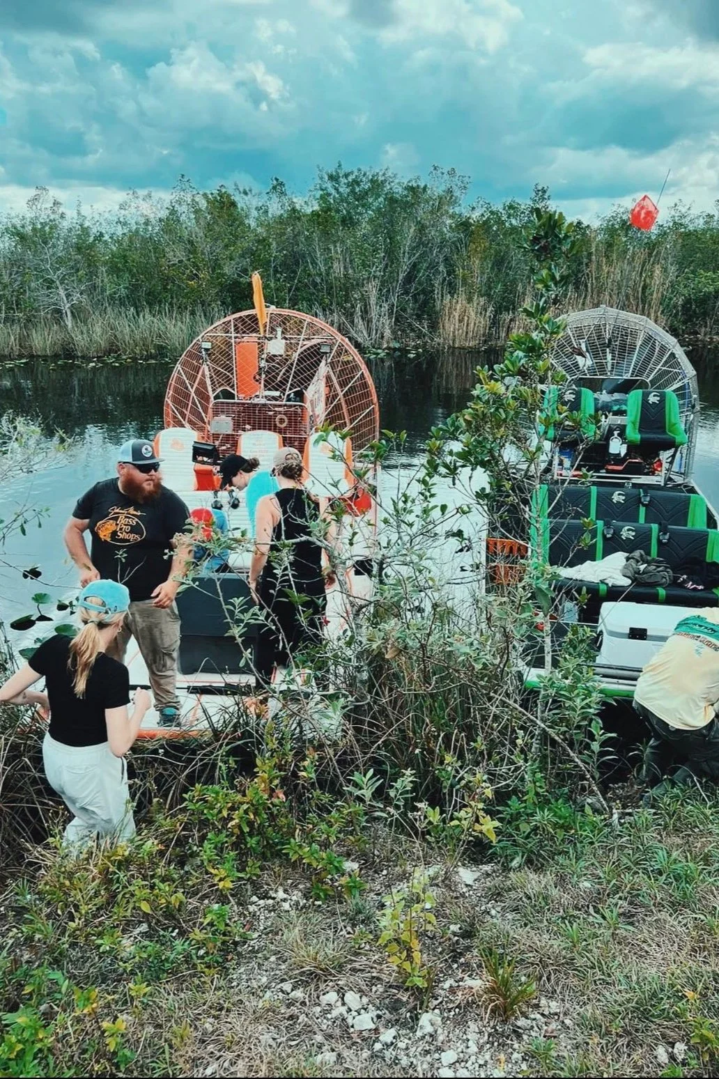 Group with airboats on a narrow Everglades waterway