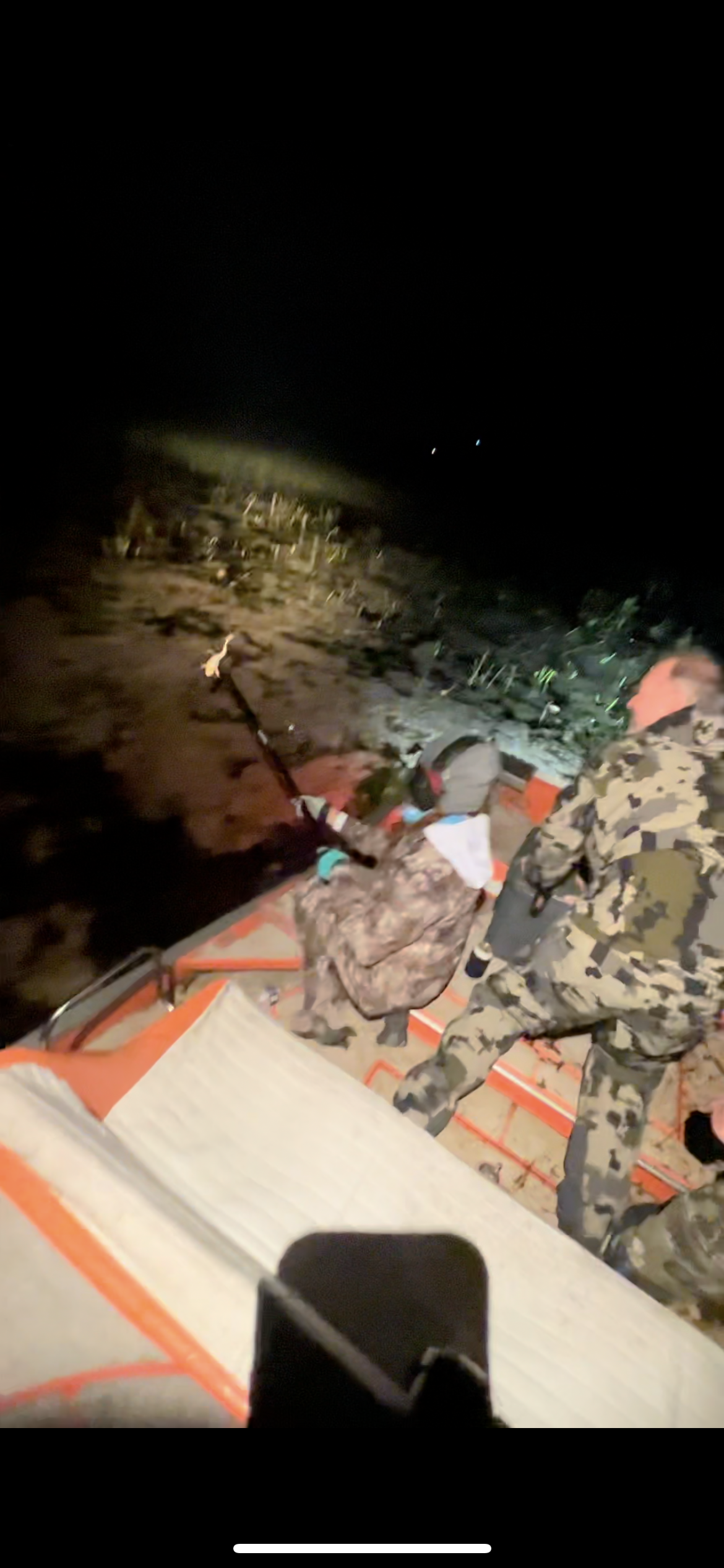 Guest with frog-gigging equipment on an airboat in the Everglades at night