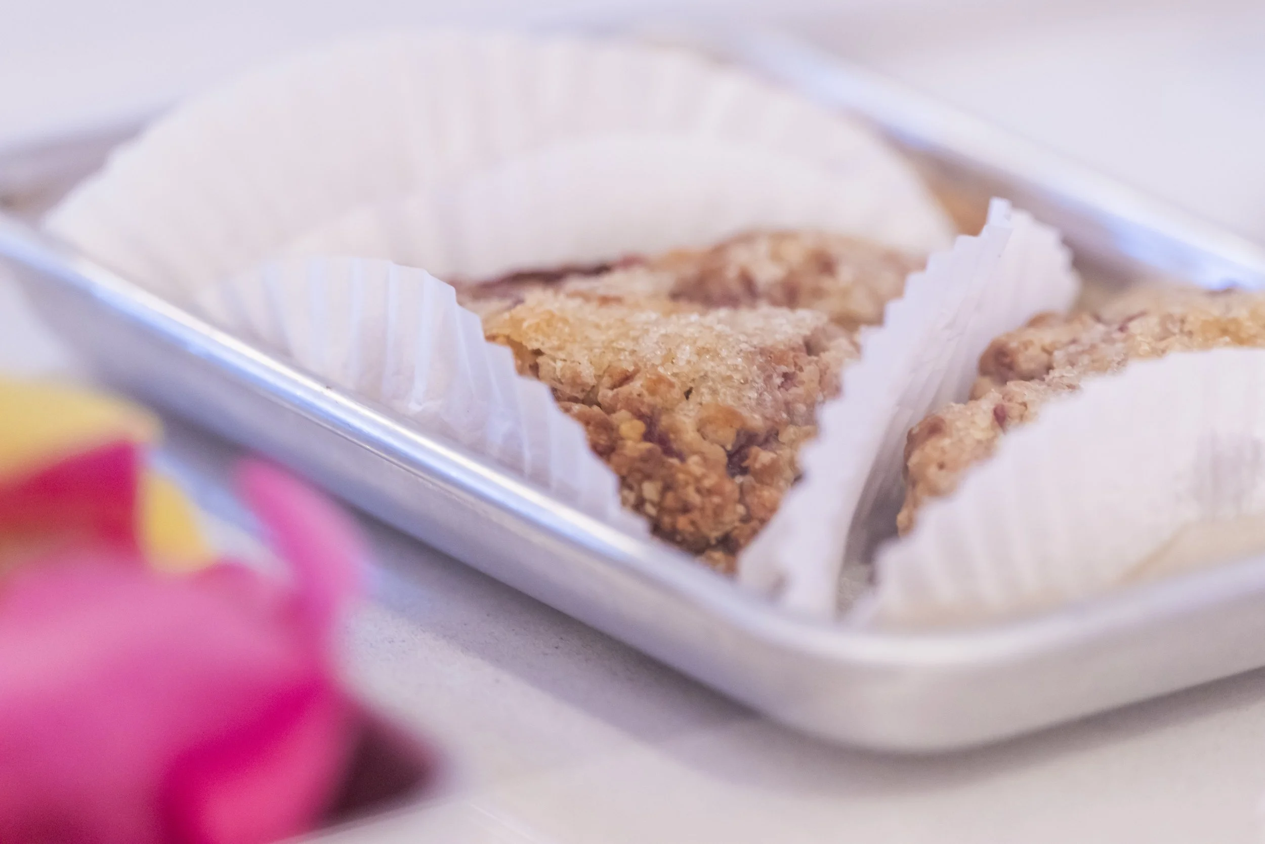 Close-up of pieces of fried chicken on a tray with white paper cups.
