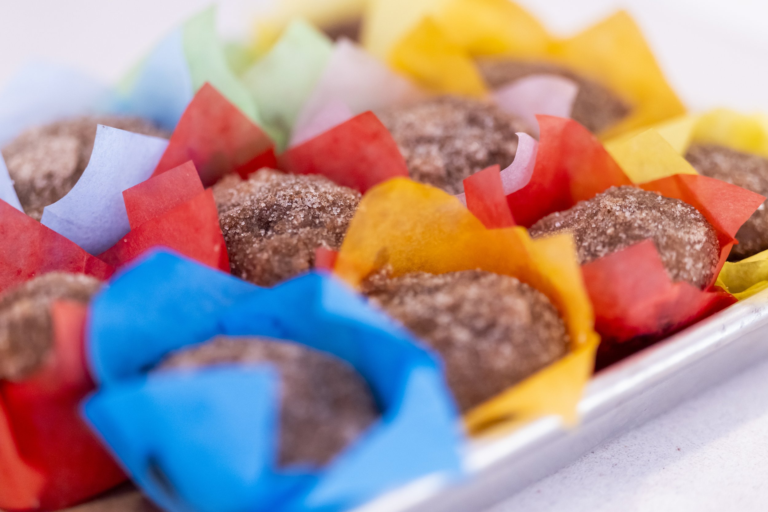 Close-up of sugar-coated chocolate truffles in colorful paper cups.