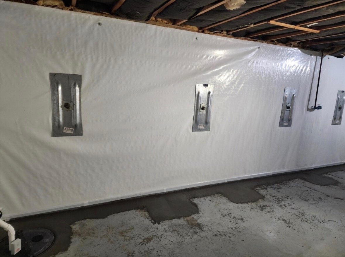 Image features basement wall with support anchors and waterproofing.
