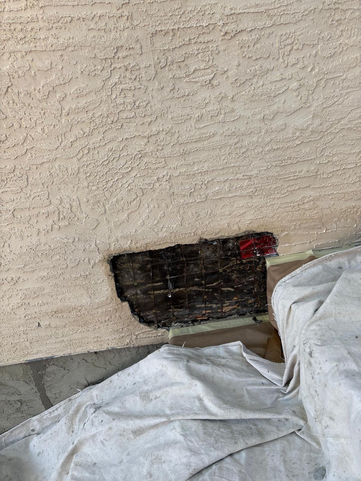 Before: Damaged stucco removed to expose underlying issues
