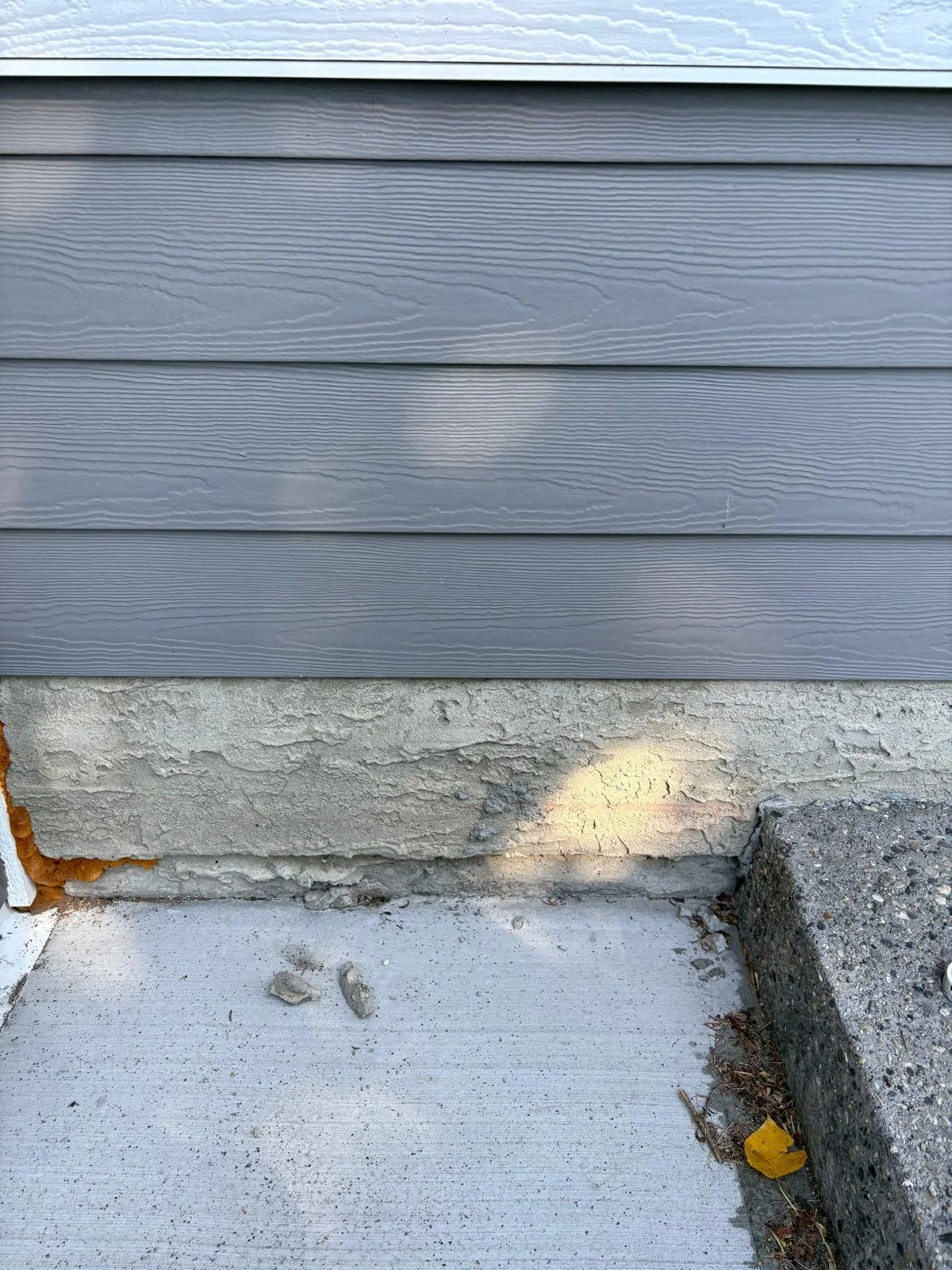 Before: Damaged, crumbling parging exposing the foundation
