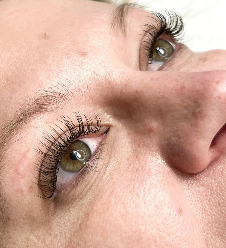 Close-up of a person's face focusing on the eyes with long eyelashes and light skin.