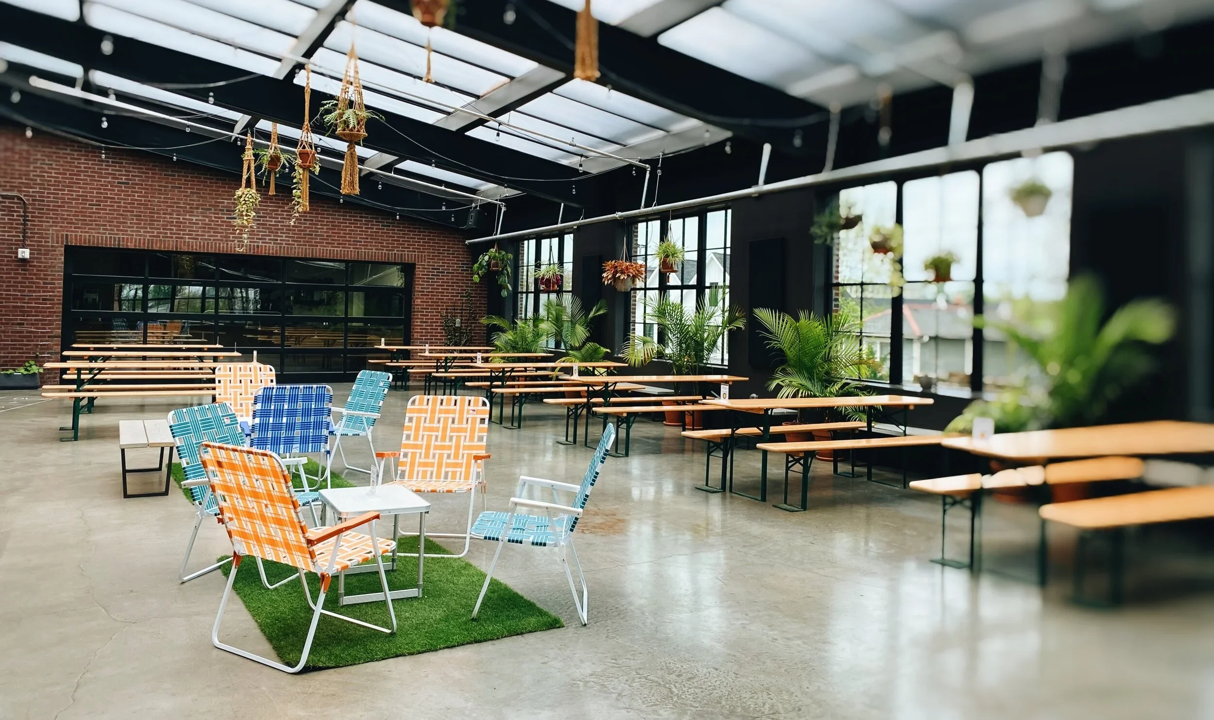 Seventh SOn Brewing interior photo showing green plants, spcious floorspan, and welcoming seating area