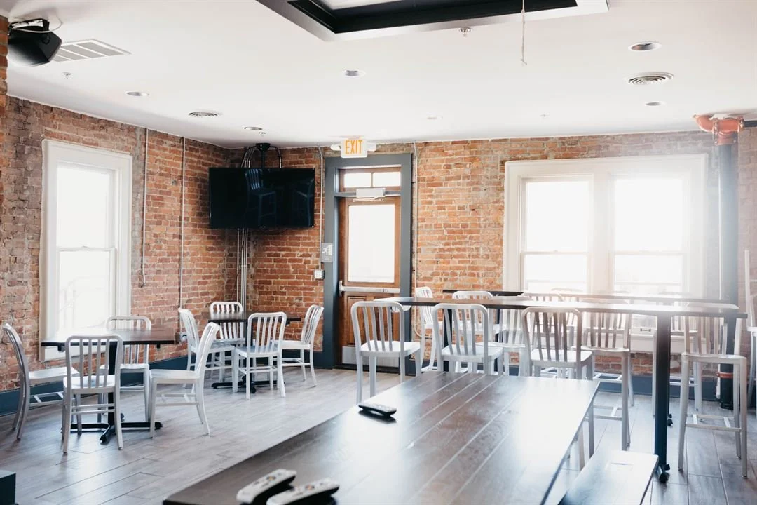 Daily Growler German Village/Brewery District Location interior, empty, with a variety of seating options, stylish urbanized brick interior, and wood decor