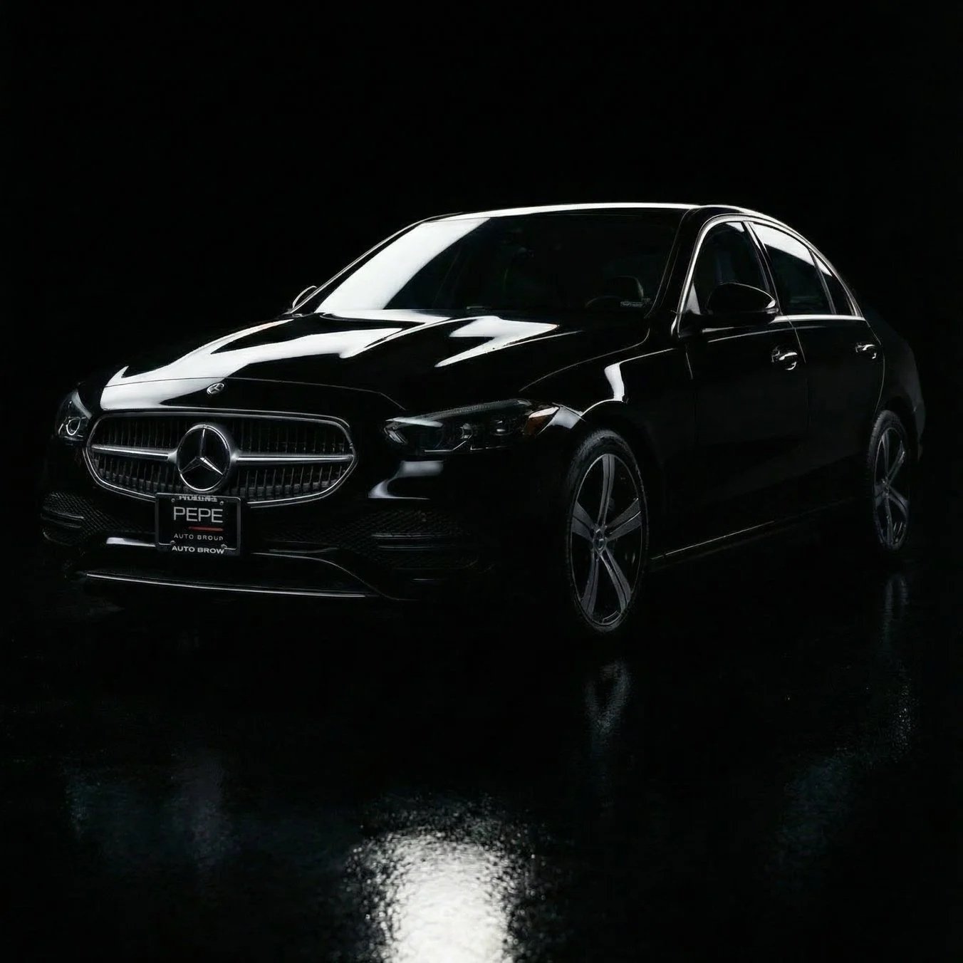 Glossy black 2022 mercedes c 300 from buckeye transportation solutions, parked in a dark cyclorama professional studio.