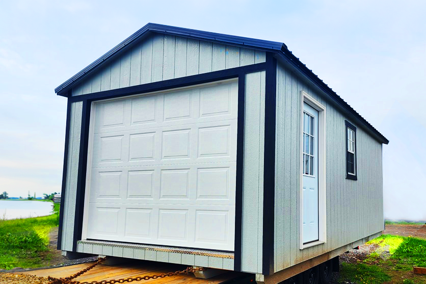 Cabanon Outaouais, Cabanons Outouais. petite maison en kit avec garage ou porte de garage blanche, construction en matériaux légers, située dans un environnement rural. Cabanon. Backyard Shed. Remise. Cabanons.