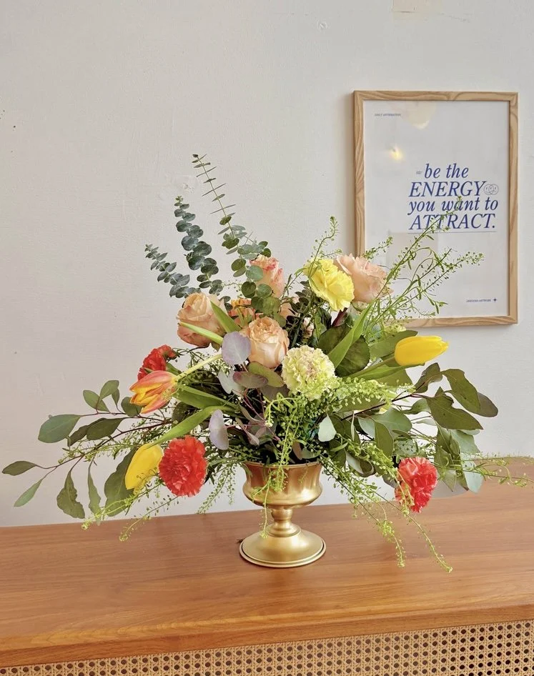 Lush mixed floral centerpiece in a gold compote vase offered as a premium event floral add on at Bat Haus in Williamsburg Brooklyn.