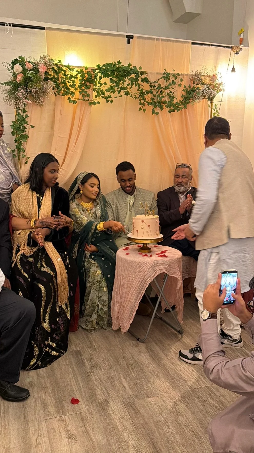 Couple celebrating their engagement at Bat Haus in Williamsburg Brooklyn, traditional ceremony with cake cutting under floral drapery, intimate private event space for up to 50 guests.