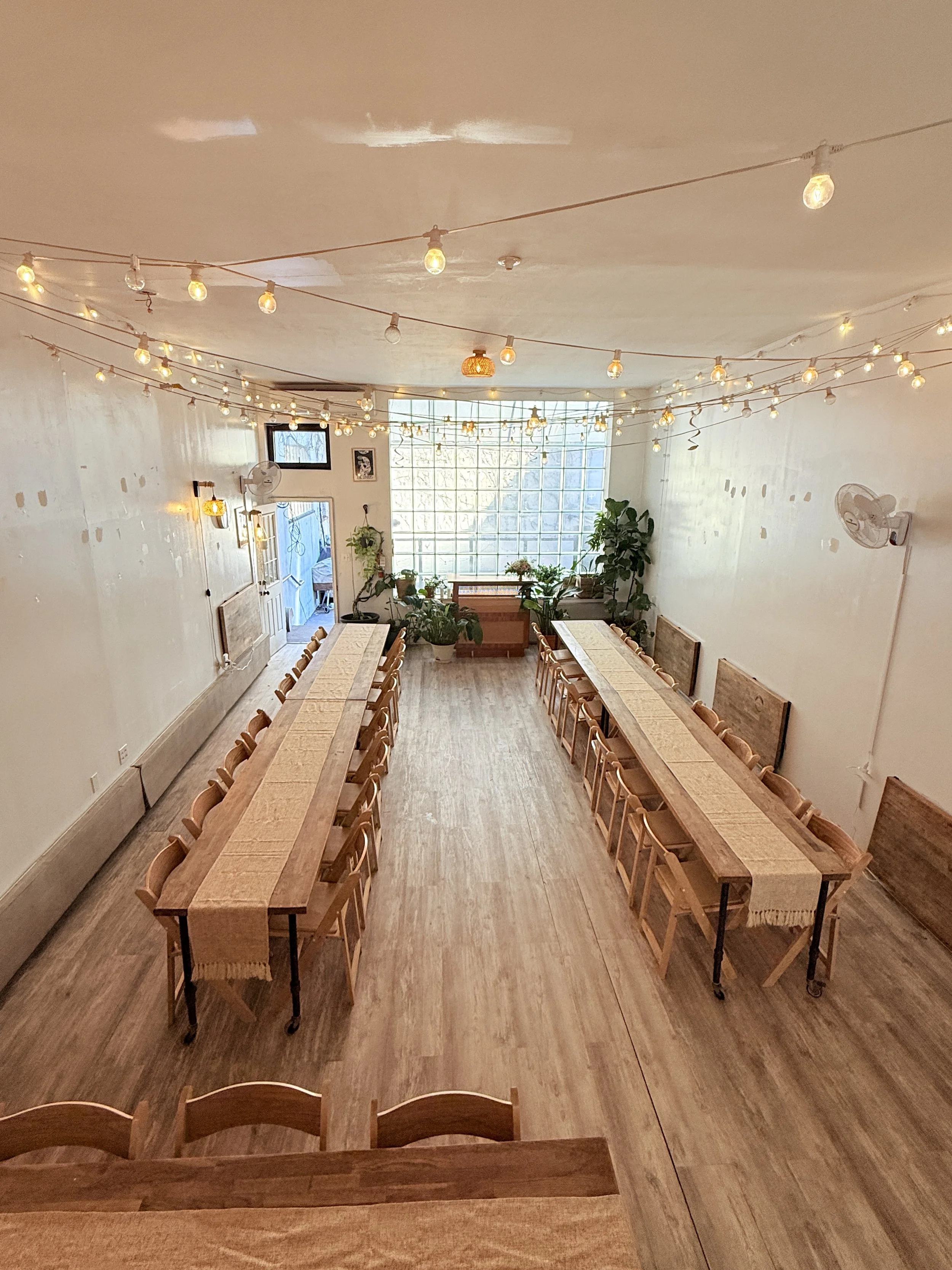 Bat Haus essential event package setup with long wooden tables and chairs arranged for a private event in the Brooklyn event space.