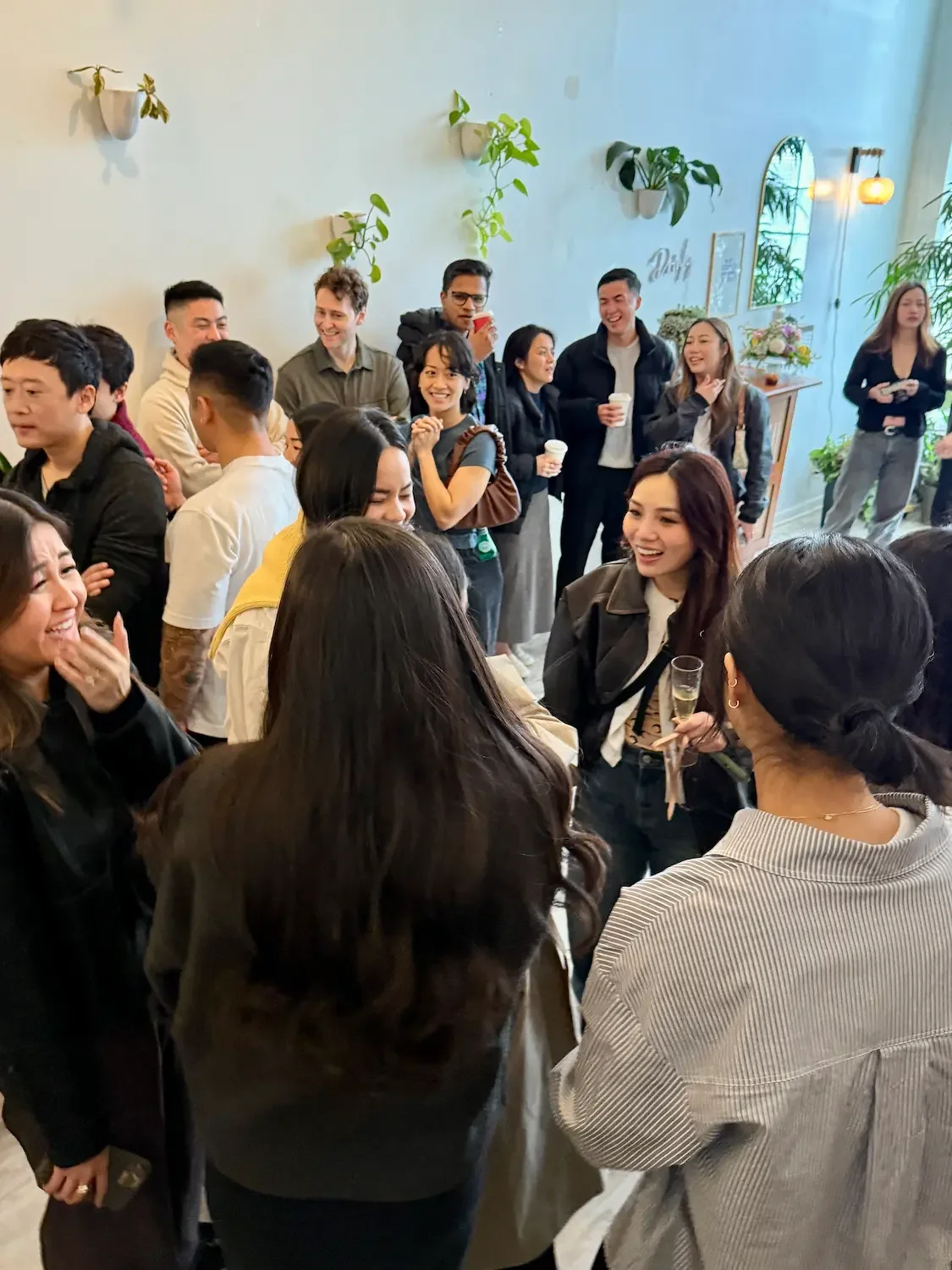 surprise proposal and engagement party celebration with guests socializing inside Bat Haus Brooklyn event space during a private gathering with drinks and natural light