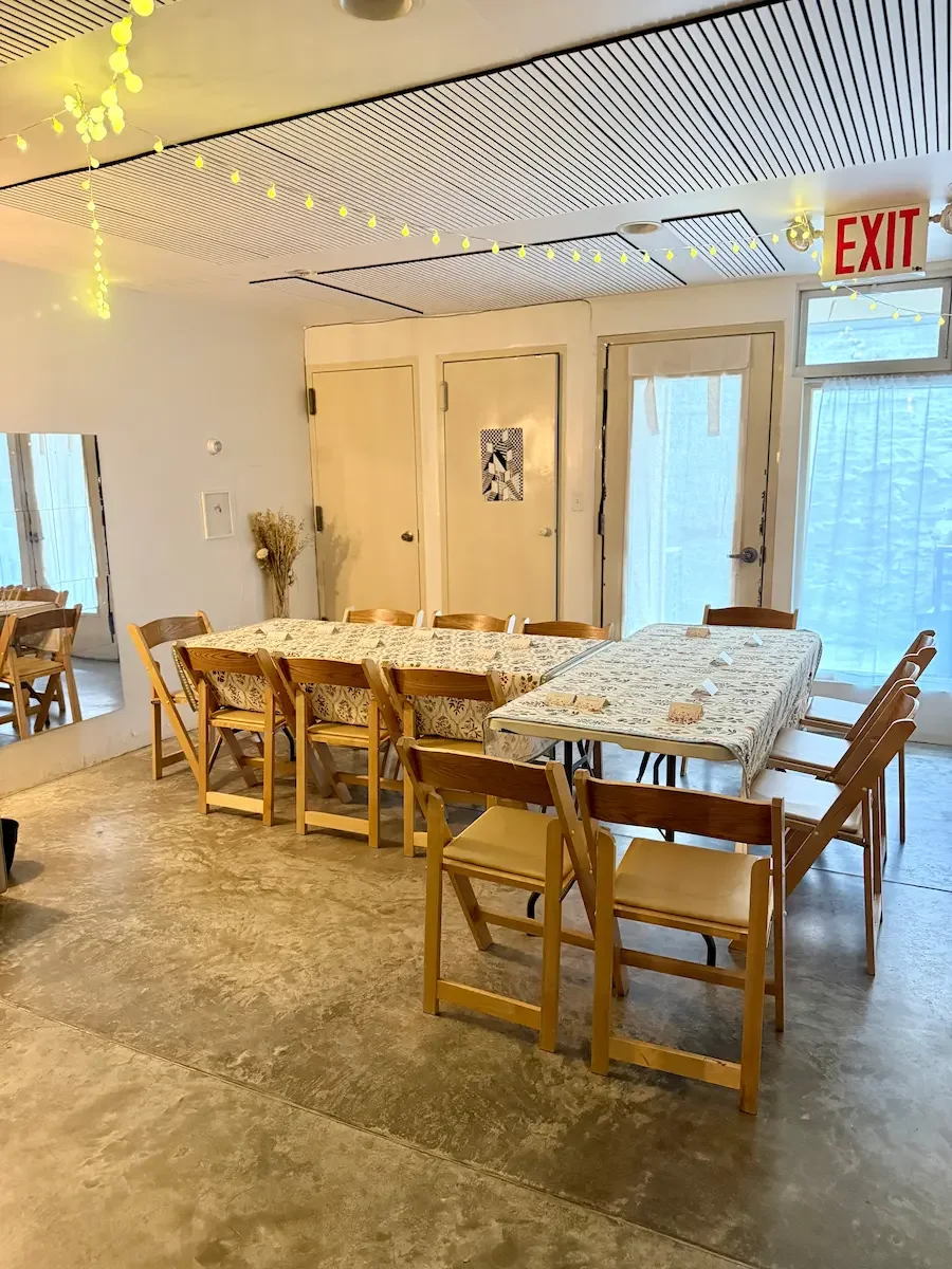 Downstairs studio set with tables and chairs for a small gathering at Bat Haus event space in Williamsburg, Brooklyn.
