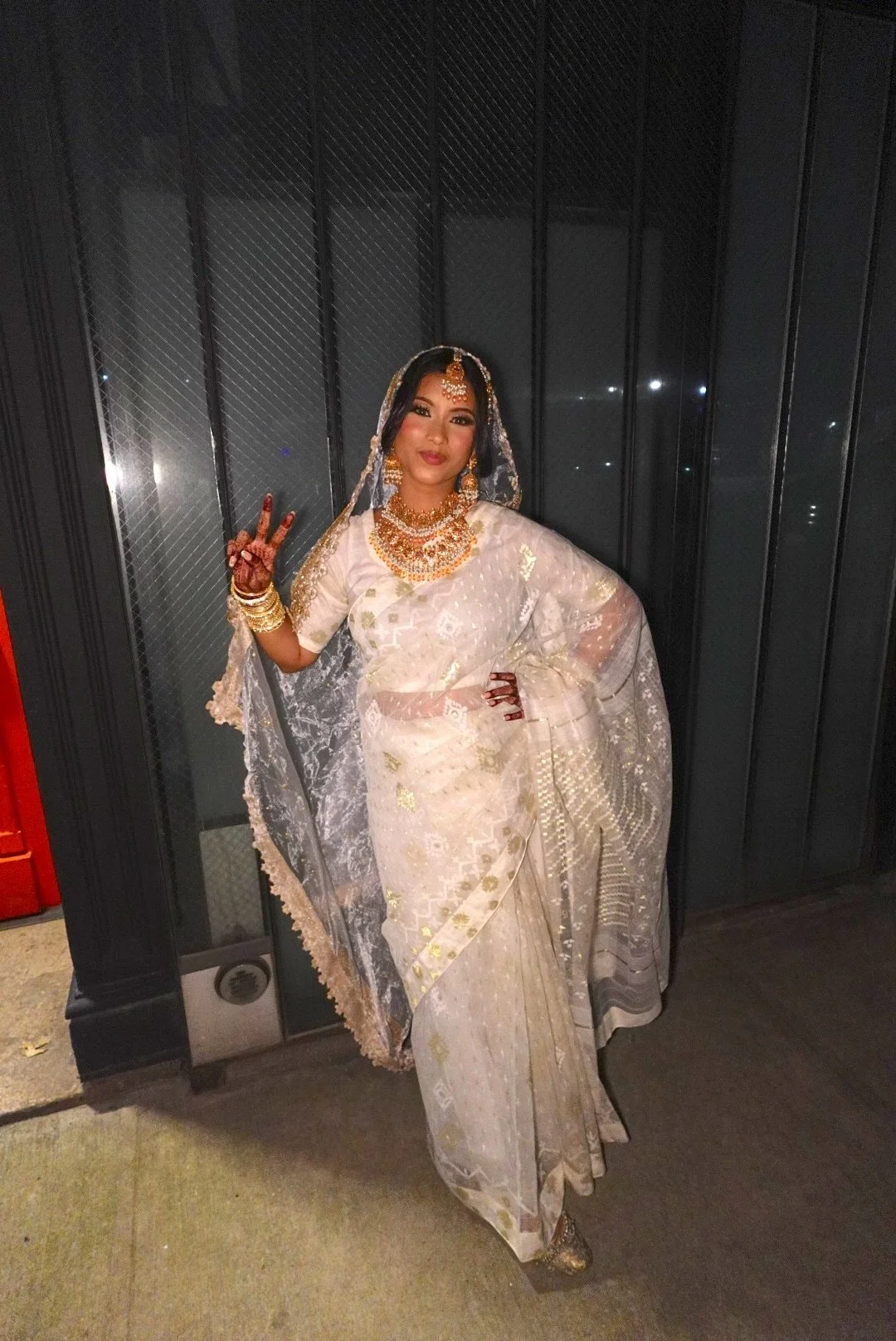Bride in a white and gold saree with veil, gold jewelry, and henna outside her Nikah at Bat Haus, an intimate Nikah venue in Williamsburg, Brooklyn