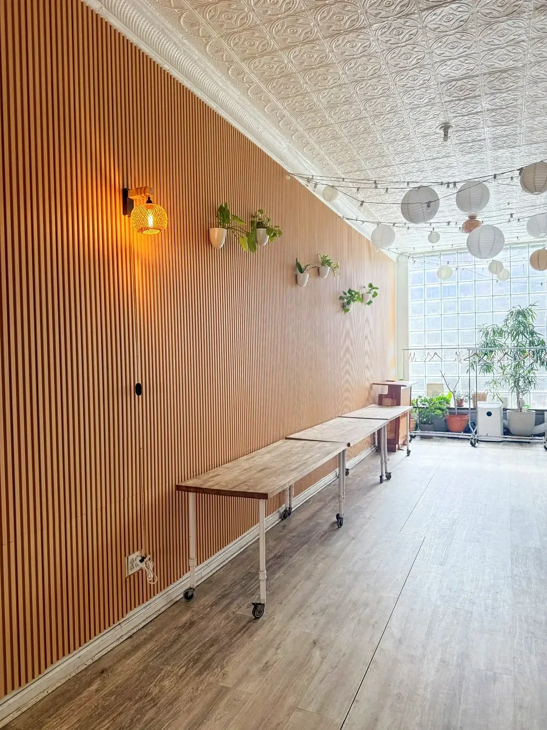 Entrance lobby at Bat Haus Brooklyn with wood panel wall, natural light, and tables for welcome setup or food and beverage display