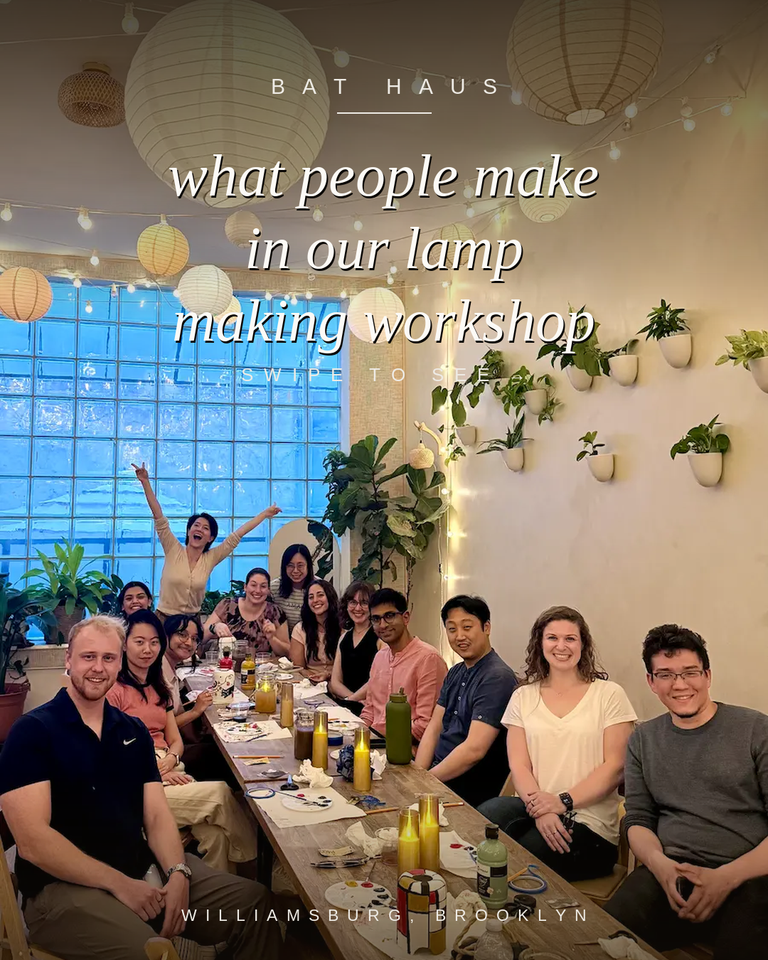 Group seated around a long table at a lamp making workshop at Bat Haus in Williamsburg, Brooklyn, with painted lamps and string lights.