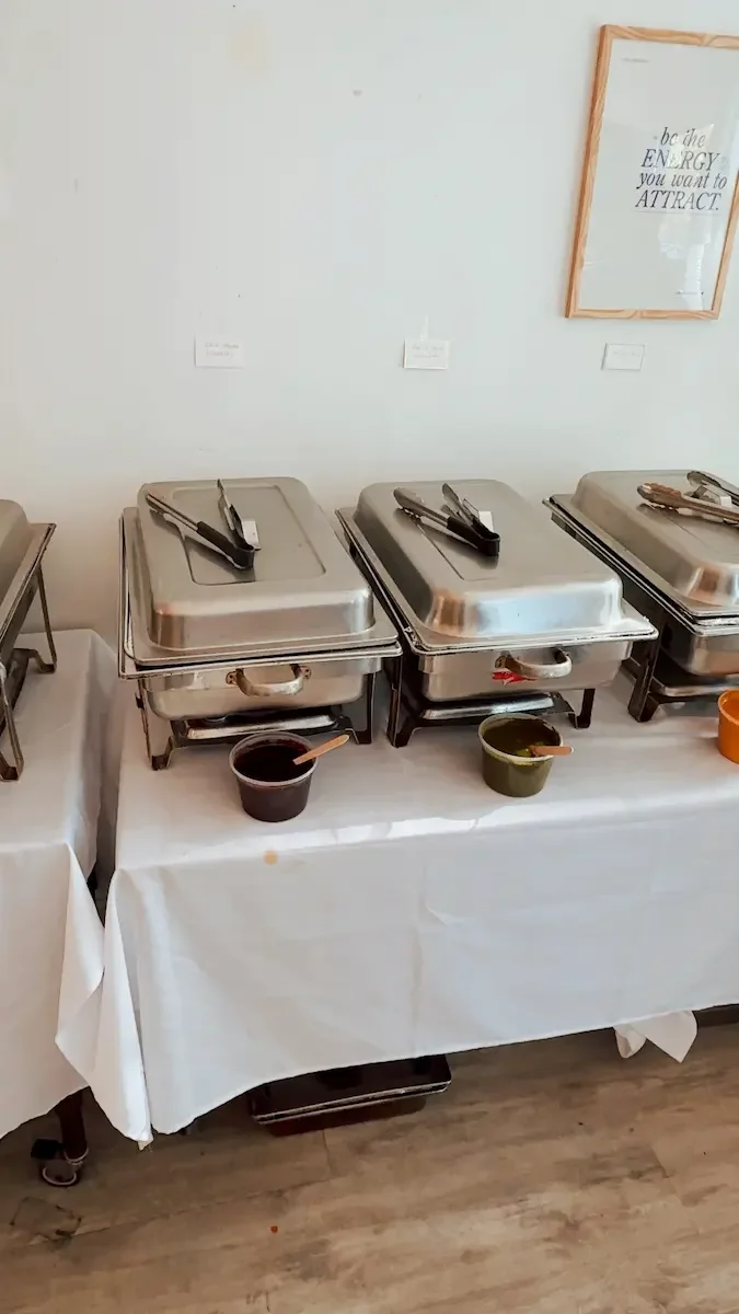 Hot buffet station at Bat Haus Brooklyn with stainless steel chafing dishes set up for catered food service during a private event.