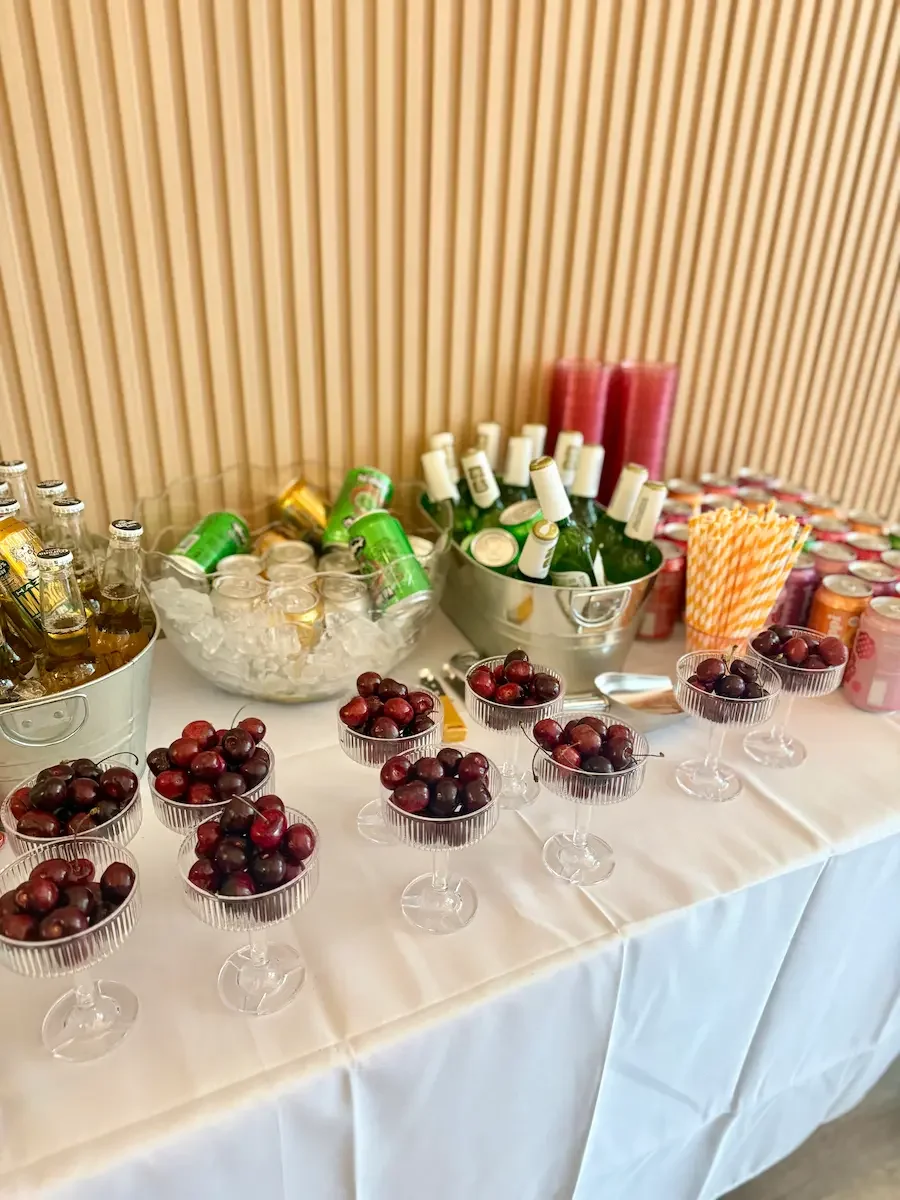 A BYO drinks table with sodas, sparkling wine on ice, and cherry cups at Bat Haus, a no-corkage event space in Williamsburg, Brooklyn.