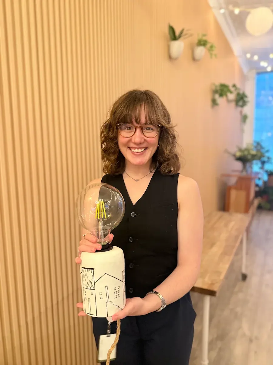 A guest holding her finished lamp at bat haus brooklyn lamp making workshop