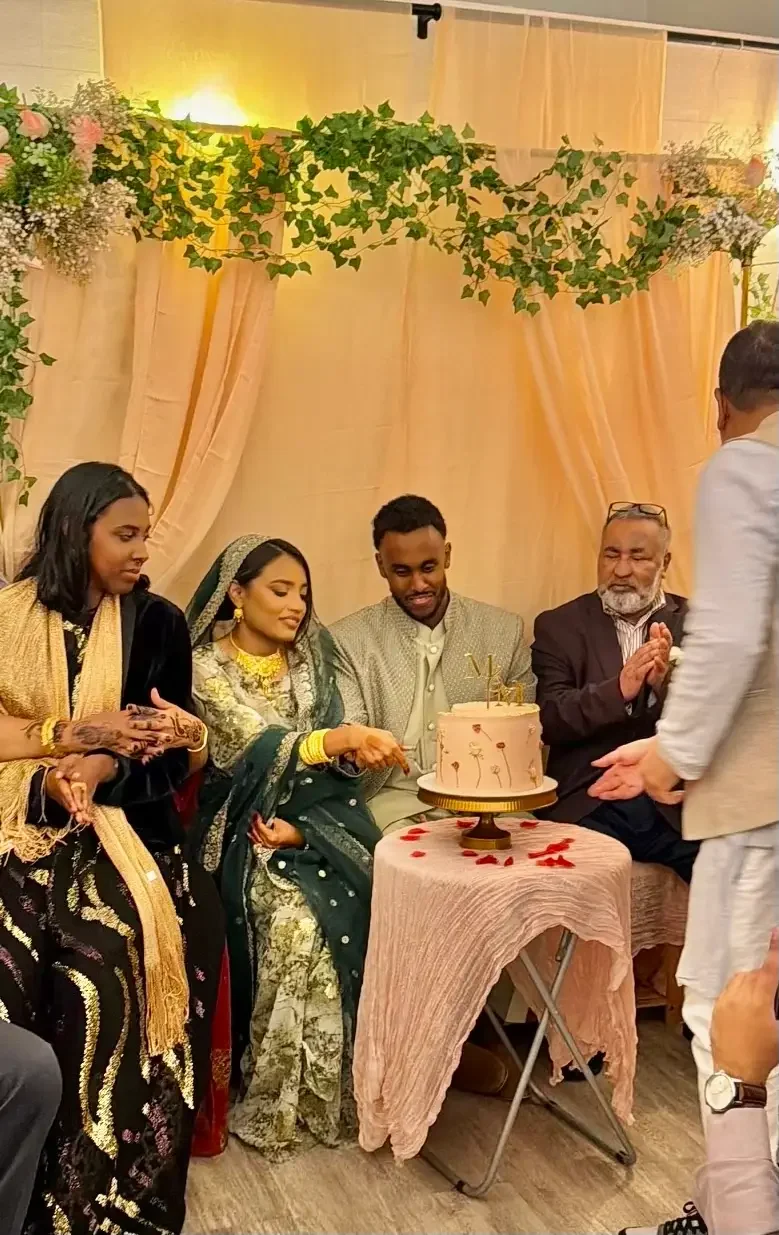 A South Asian couple cutting their wedding cake with family at Bat Haus in Williamsburg, Brooklyn.