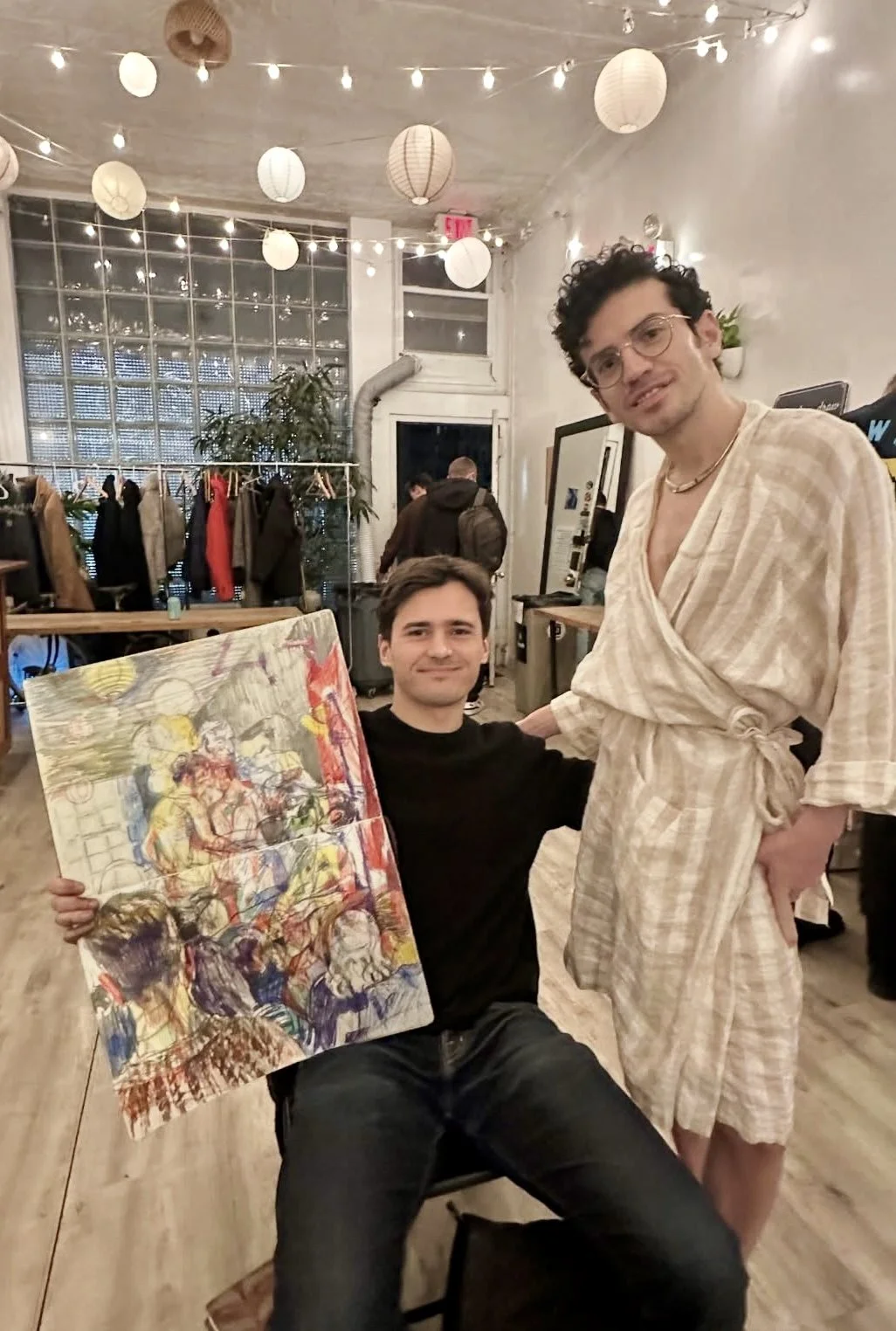 Artist holding a large colorful painting created during Drink n Draw at Bat Haus, a lively Brooklyn art event with live model and open studio drawing