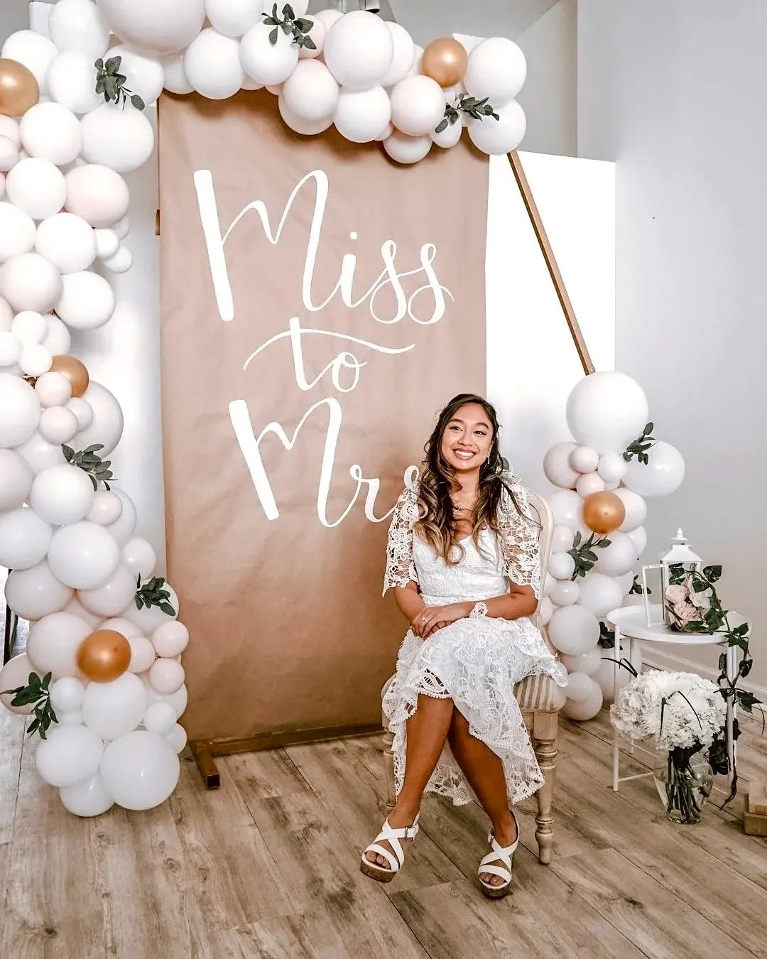 A bride seated at a 'Miss to Mrs' balloon backdrop at her bridal shower at Bat Haus in Williamsburg, Brooklyn.