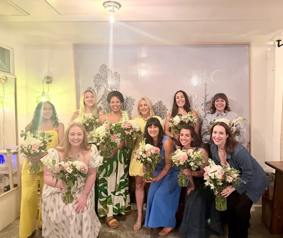 A group holding their handmade bouquets after a guided birthday floral arranging workshop at Bat Haus in Williamsburg, Brooklyn.